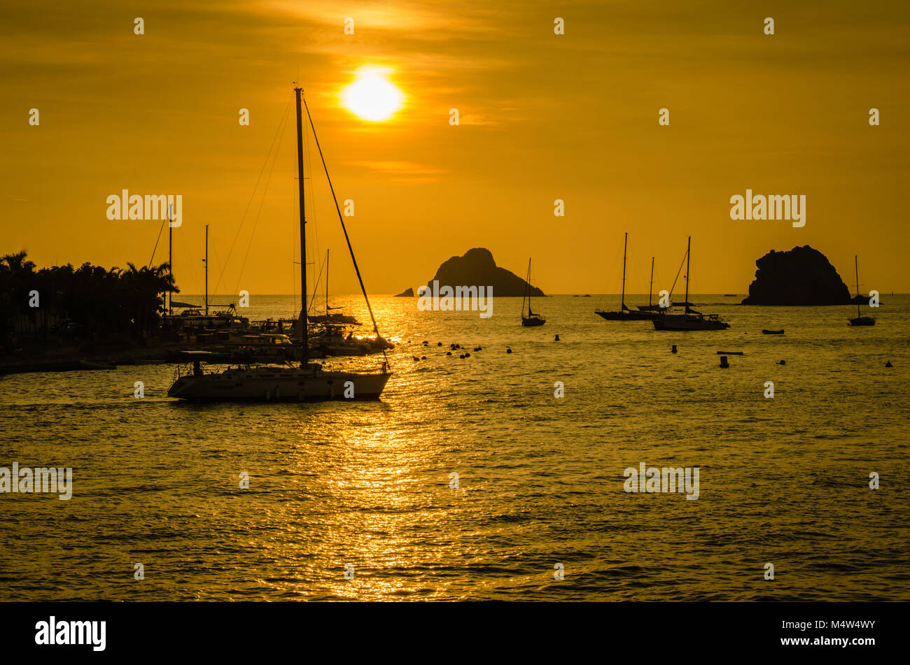 Coucher du soleil tropical sur silhoutted voiliers dans le port, sur l'île de Saint Barthélemy. Banque D'Images