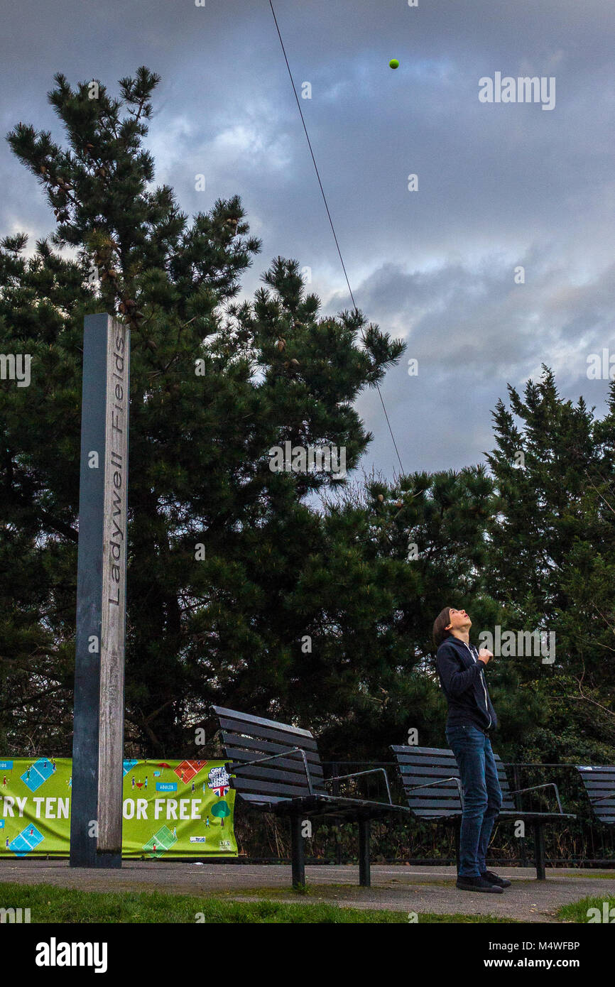 Boy lance balle de tennis dans l'air Banque D'Images