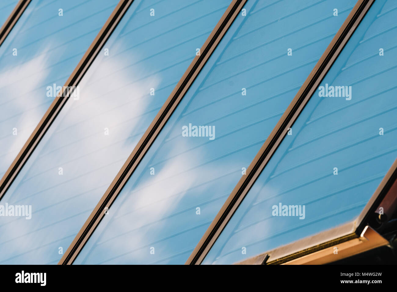 Panneau solaire sur le toit de la maison. L'énergie solaire. Le comité reflète le ciel bleu avec des nuages. Banque D'Images