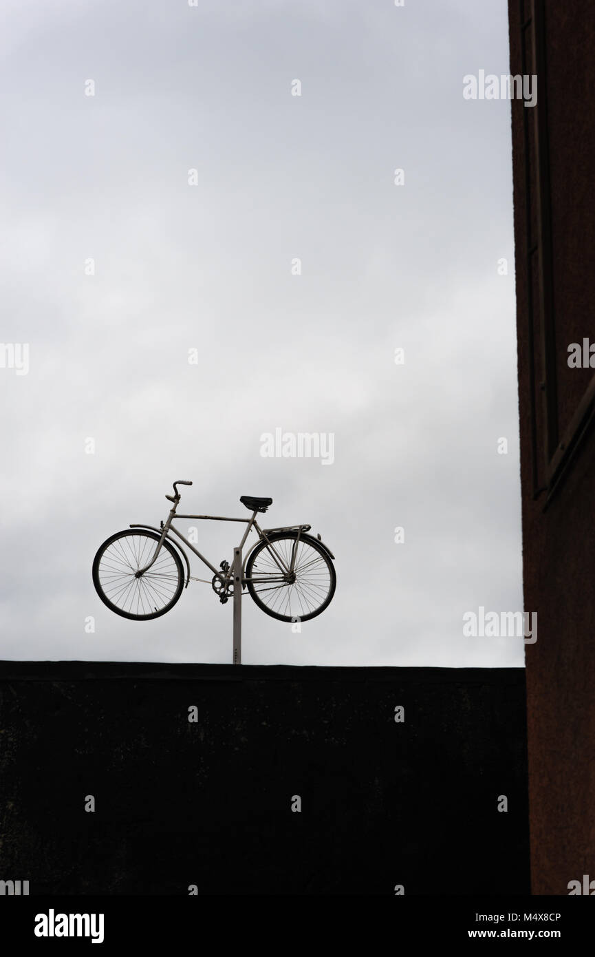 Un vélo sur un poteau indique probablement un bike shop. Vilnius, Lituanie. Banque D'Images