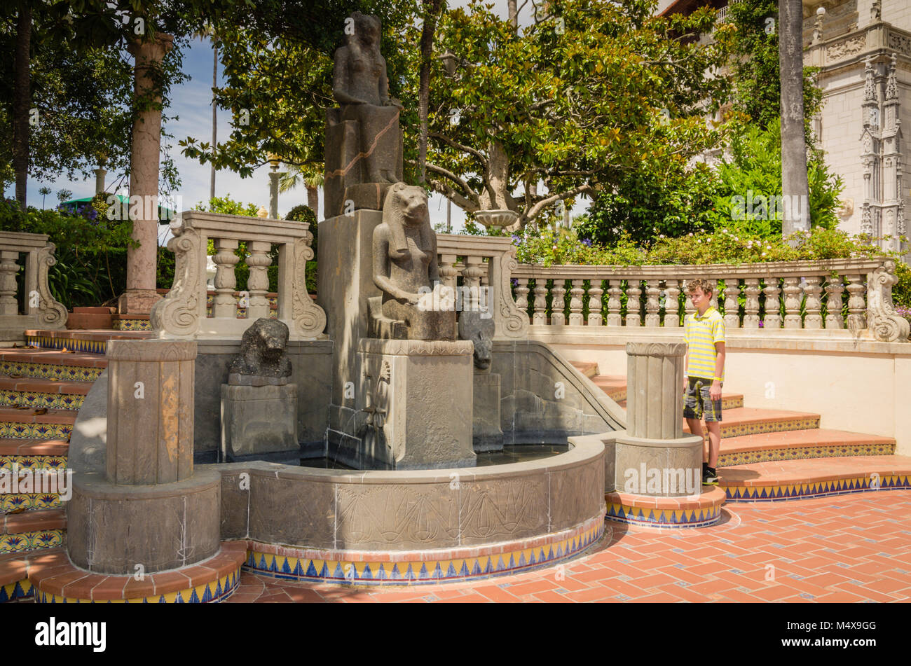 Jeune garçon admire la statue de Sekhmet, la déesse égyptienne à tête de lion et le corps d'une femme à Hearst Castle, San Simeon, CA. Banque D'Images