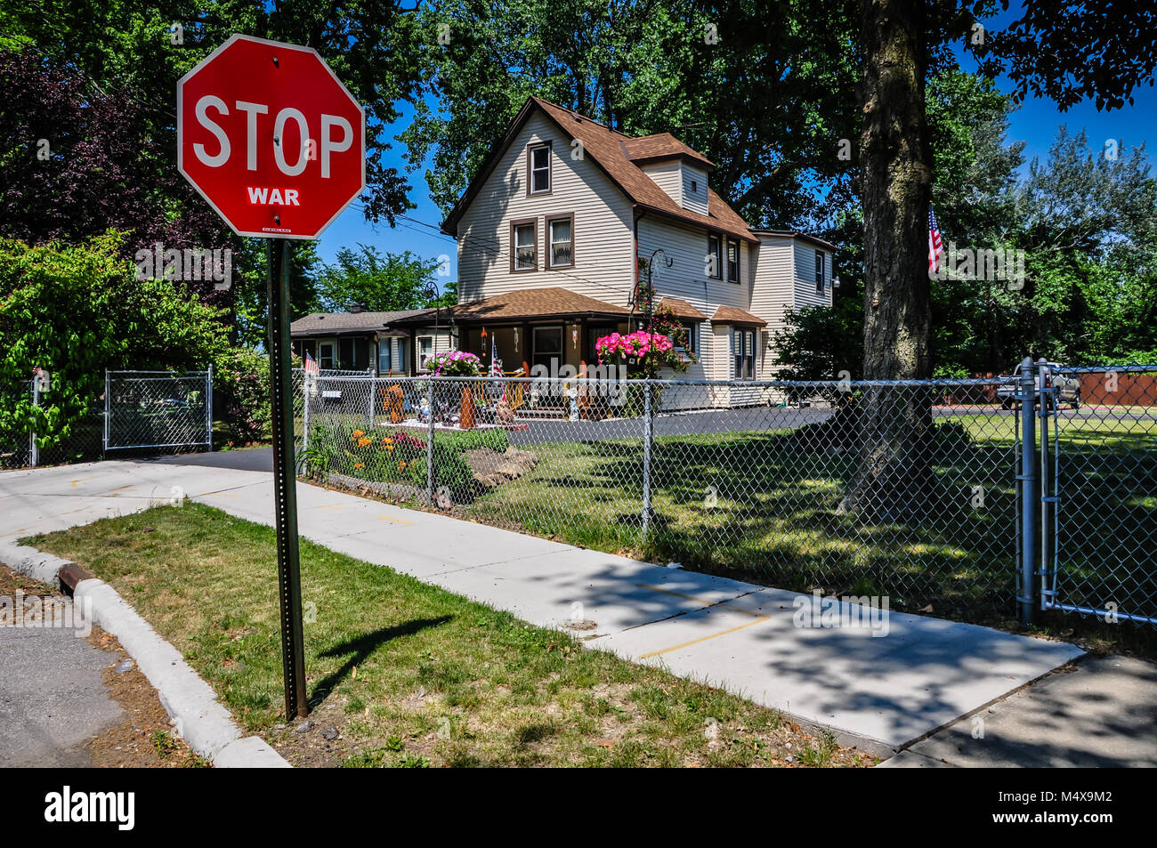 Un panneau d'arrêt dans une petite ville idyllique dans les États-Unis d'Amérique, avec le message 'Stop à la guerre.' Banque D'Images