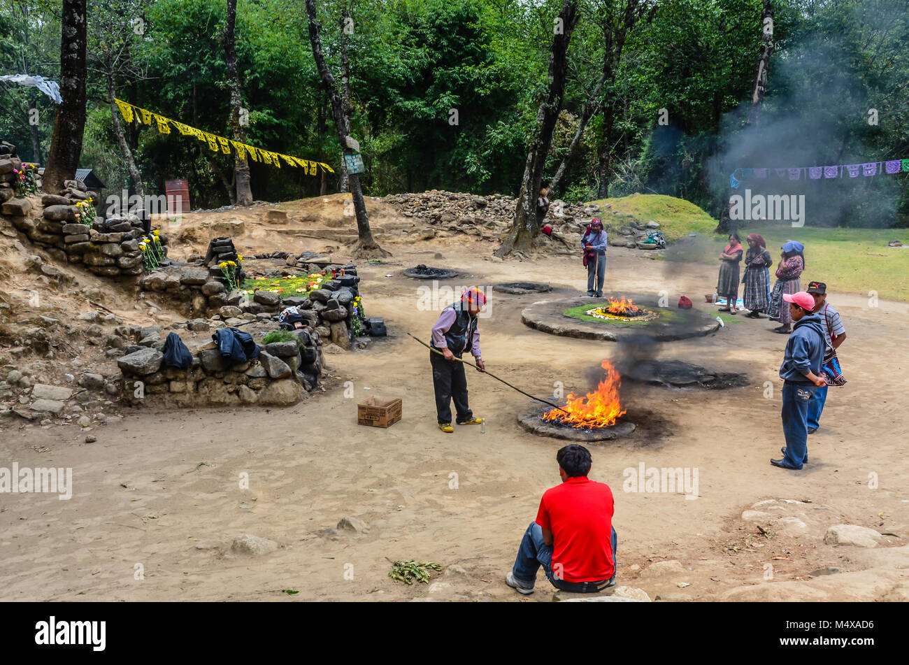 L'homme du Guatemala a tendance l'incendie à un temple maya à côté de ruines antiques. Iximche est un lieu de pèlerinage sacré pour les Mayas. Banque D'Images