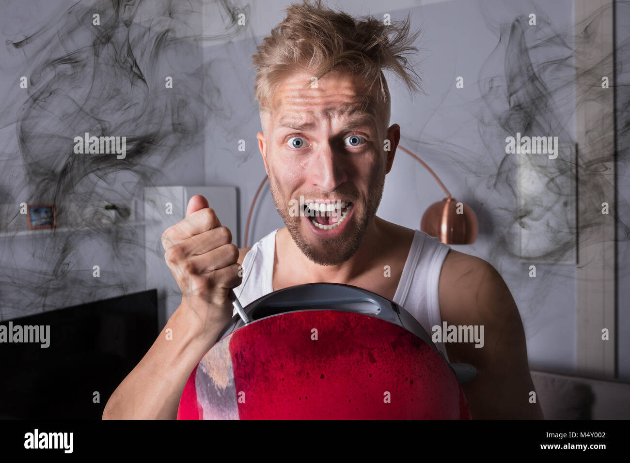 Portrait d'un homme en colère Holding grille-pain à la maison Banque D'Images