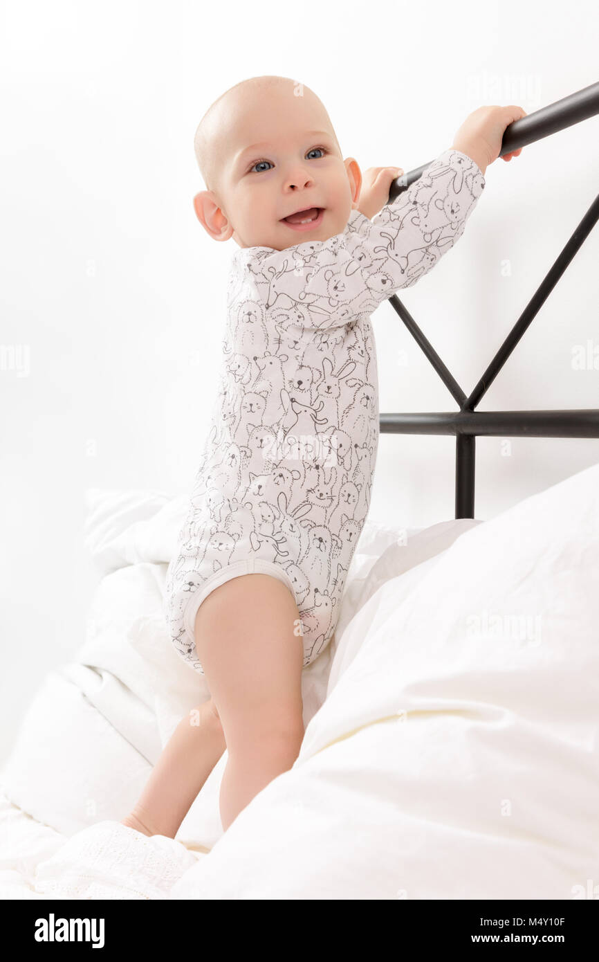Cute Little Smiling Baby Boy Bebe Debout Sur Le Lit Des Parents La Maintenant Sur Le Lit L Enfant Tente D Abord De Se Lever Photo Stock Alamy