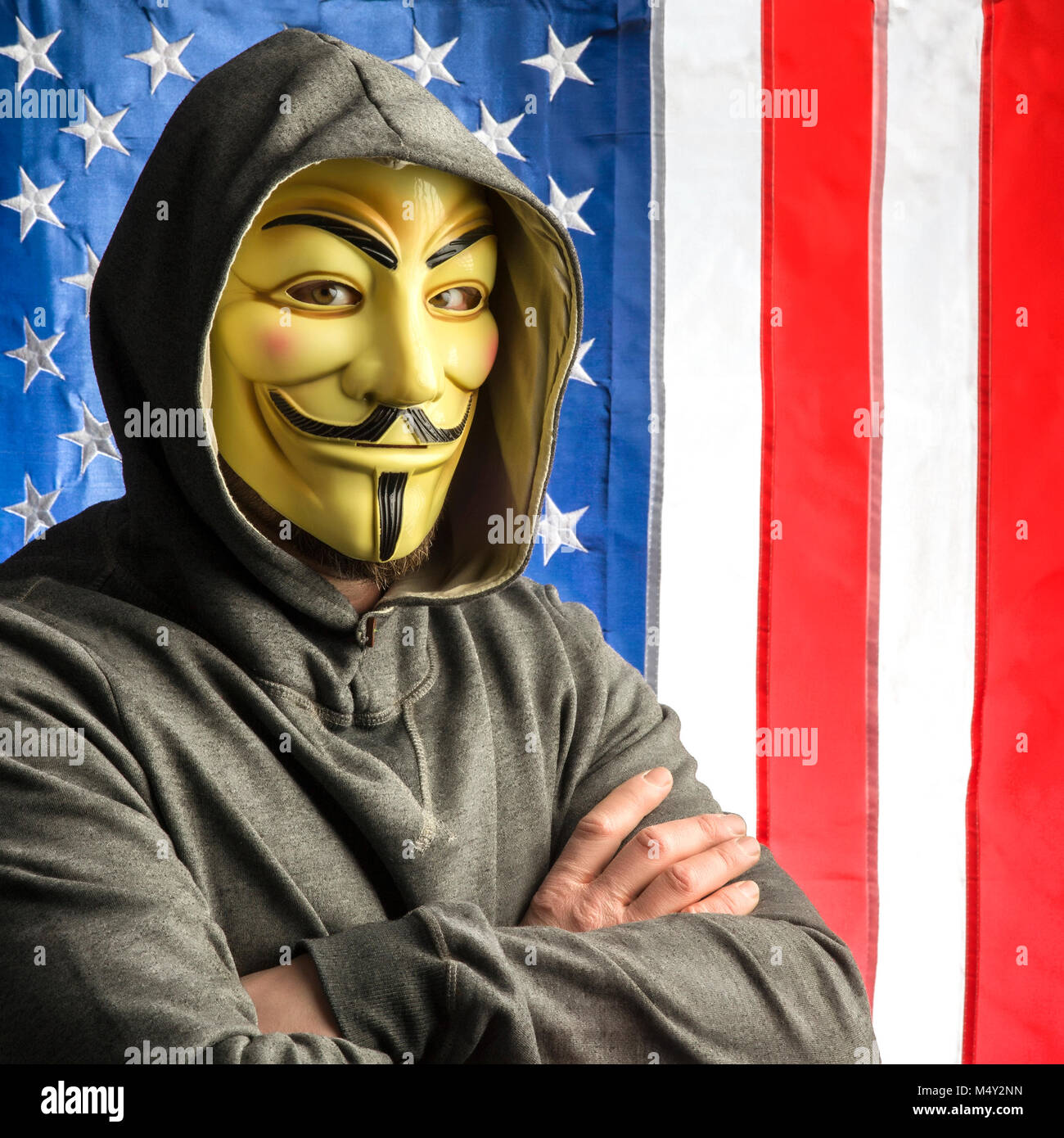 MILAN,Italie, Février, 2018 : Hacker crossing arms anonymus usure masque avec american old glory flag en arrière-plan.Editorial photo. Banque D'Images