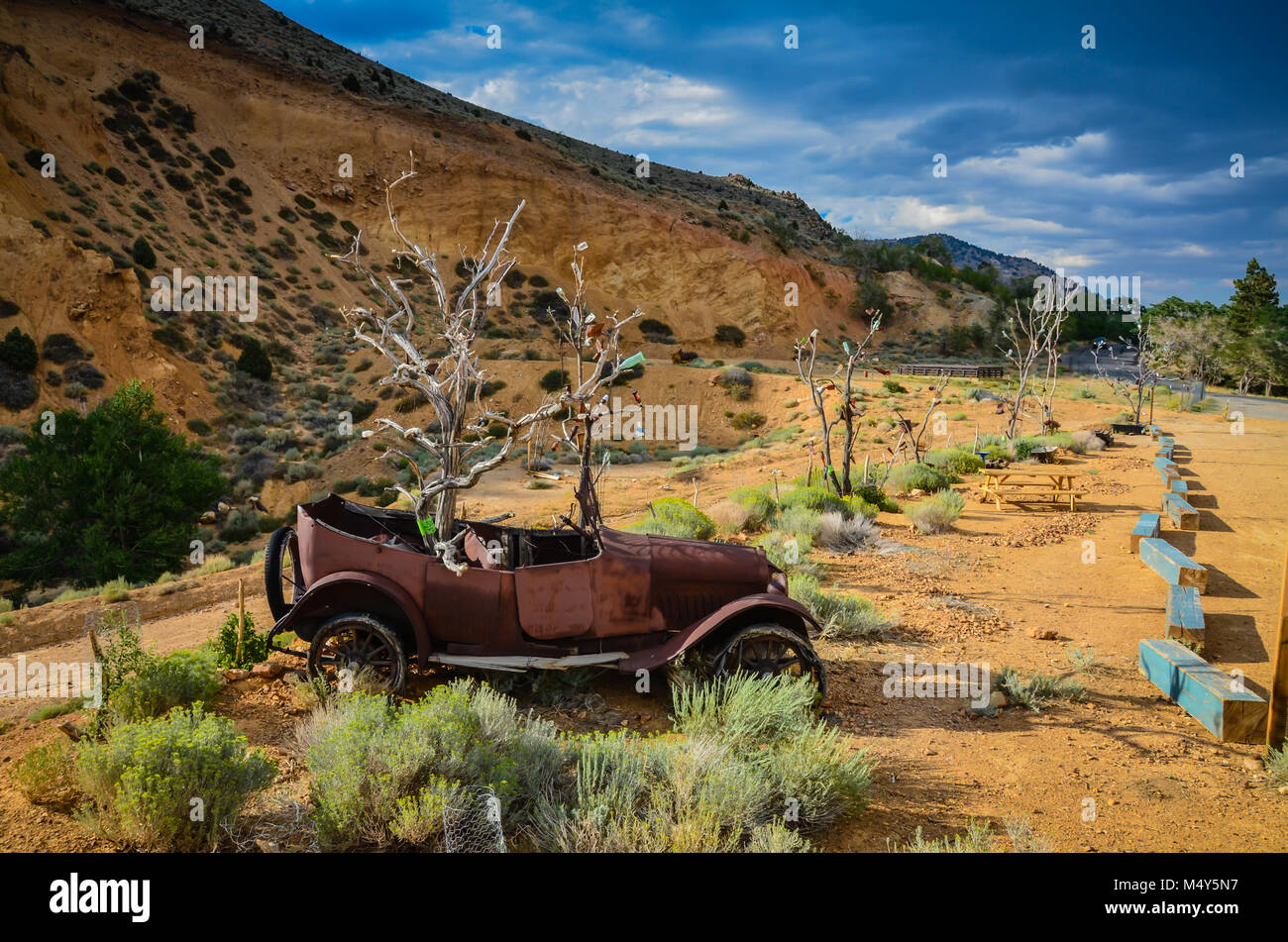 Rusty old vintage car transformé en germination de sculptures en plein air de 14 mètres d'arbres morts avec des bouteilles de bière à Virginia City, NV. Banque D'Images