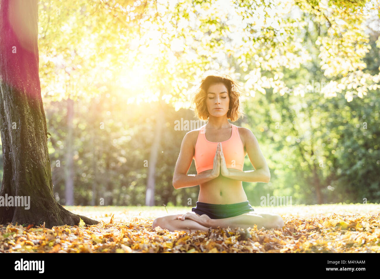 Jeune femme pratiquant le yoga dans la nature. Banque D'Images