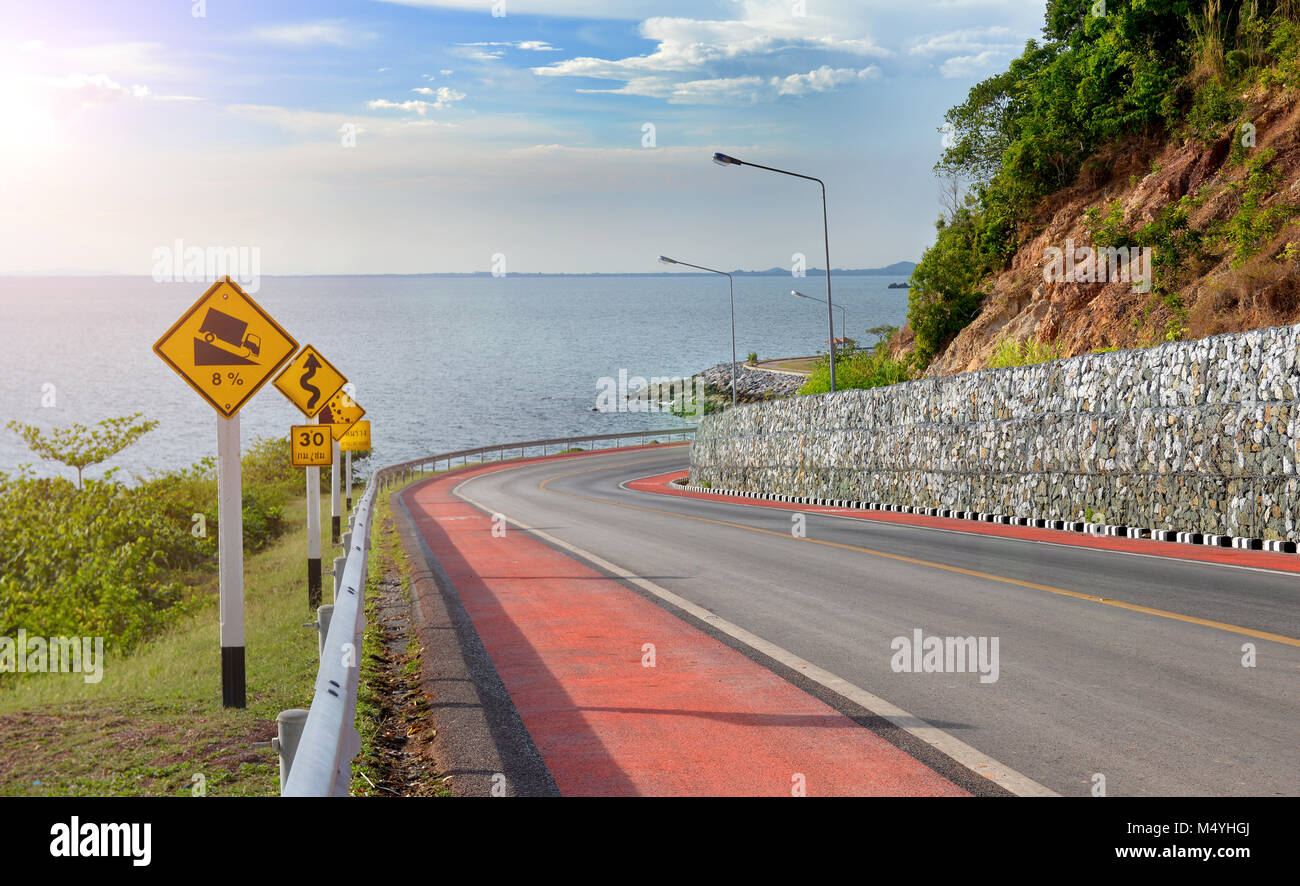 Symbole d'avertissement de trafic pour signer la protection de la route de montagne photo dans l'éclairage solaire. Banque D'Images