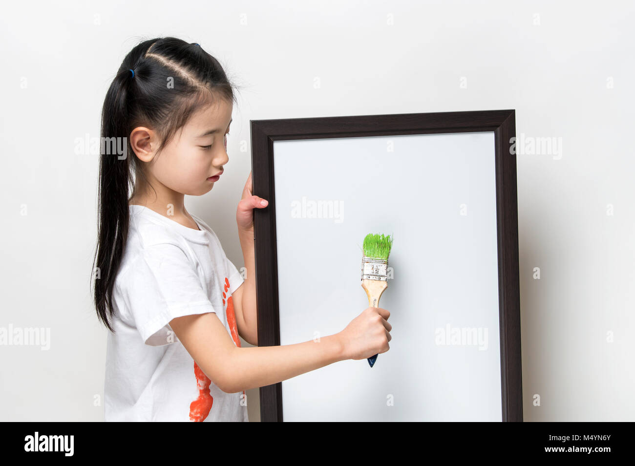 Jolie petite fille asiatique avec un pinceau et bannière blanche Banque D'Images