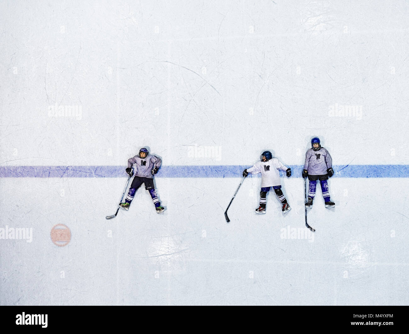 Les joueurs de hockey sur glace allongé sur rink Banque D'Images