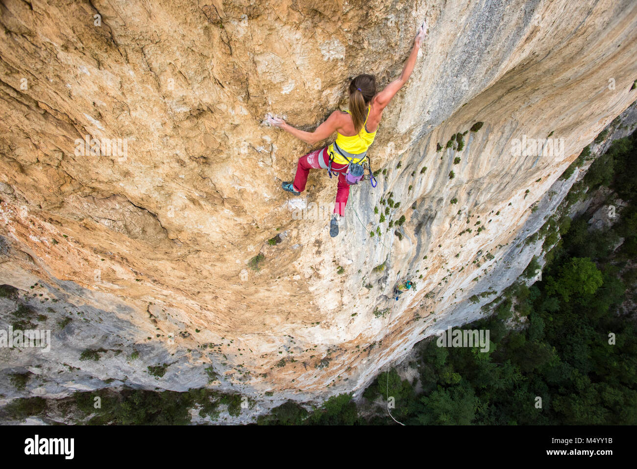 Vue de dessus de female rock climber climbing rock face, Gorges du Verdon, Alpes de Haute-Provence, France Banque D'Images