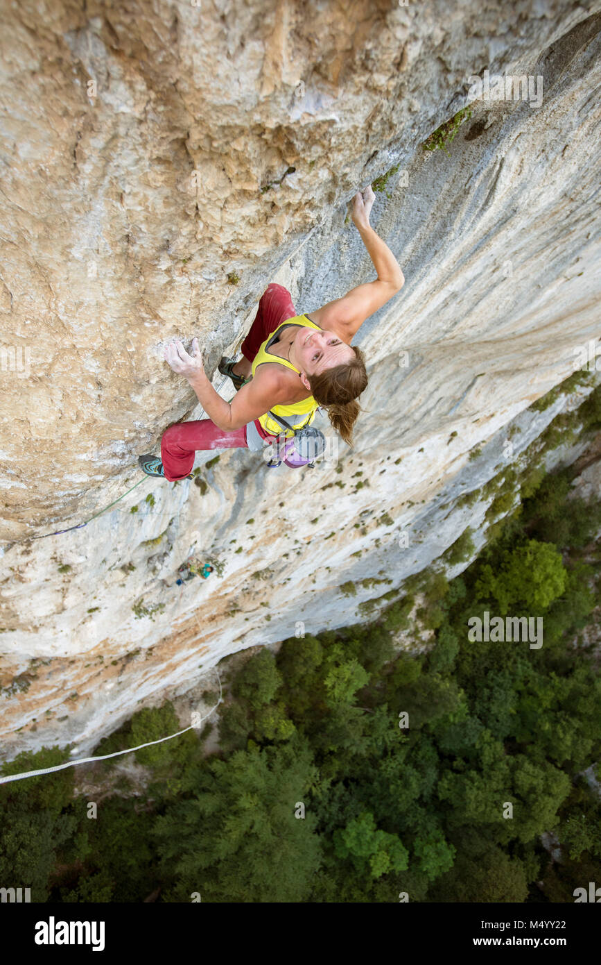 Vue de dessus de female rock climber climbing rock face, Gorges du Verdon, Alpes de Haute-Provence, France Banque D'Images