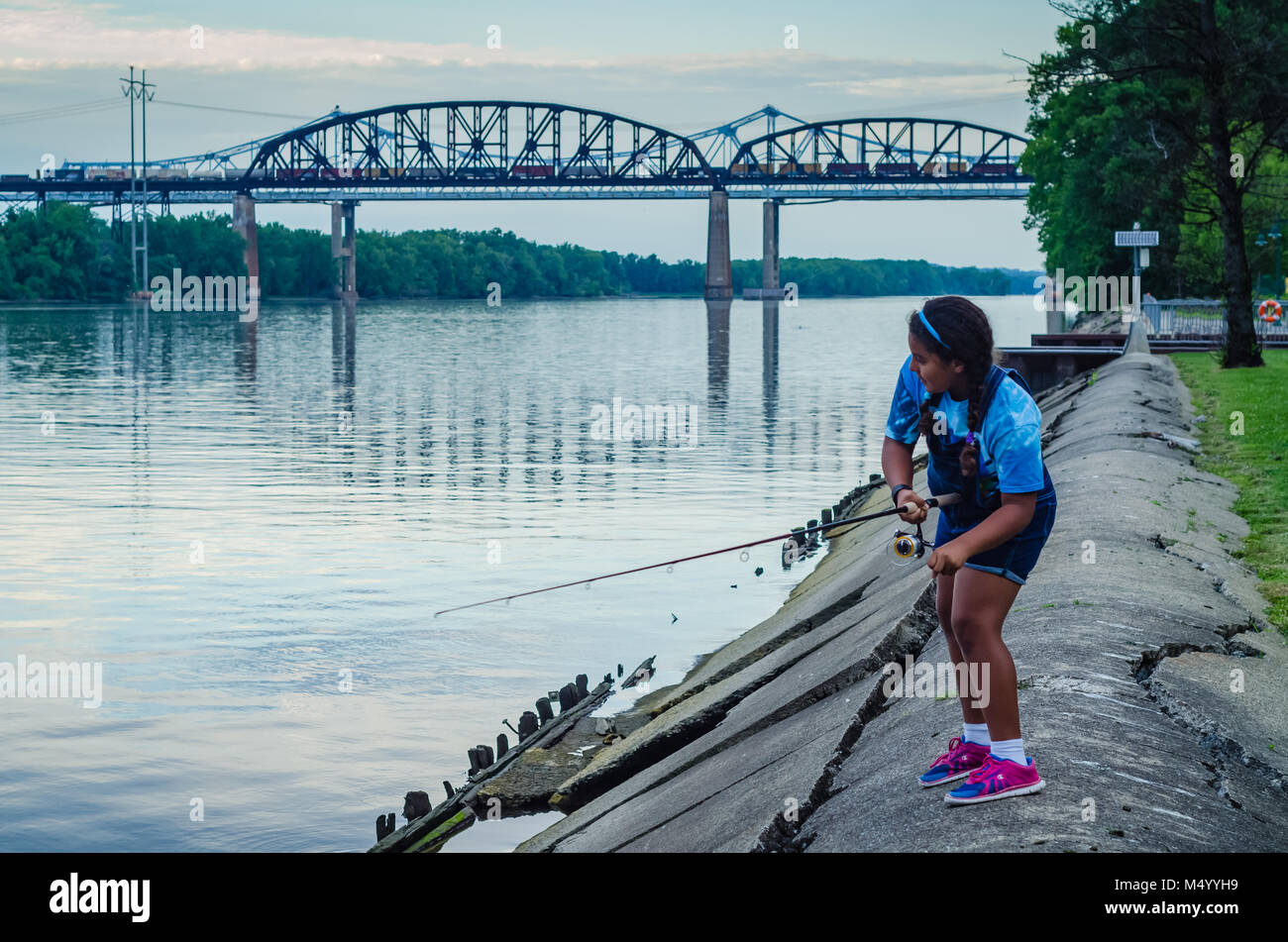 Young Hispanic girl fishing sur Hudson River shore bank à Schodack Island State Park in Schodack Landing, New York. Banque D'Images