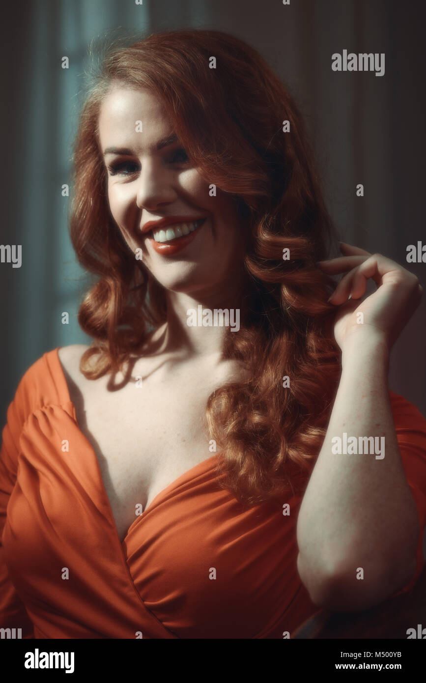 Image style cinématographique de femme aux longs cheveux rouges Banque D'Images