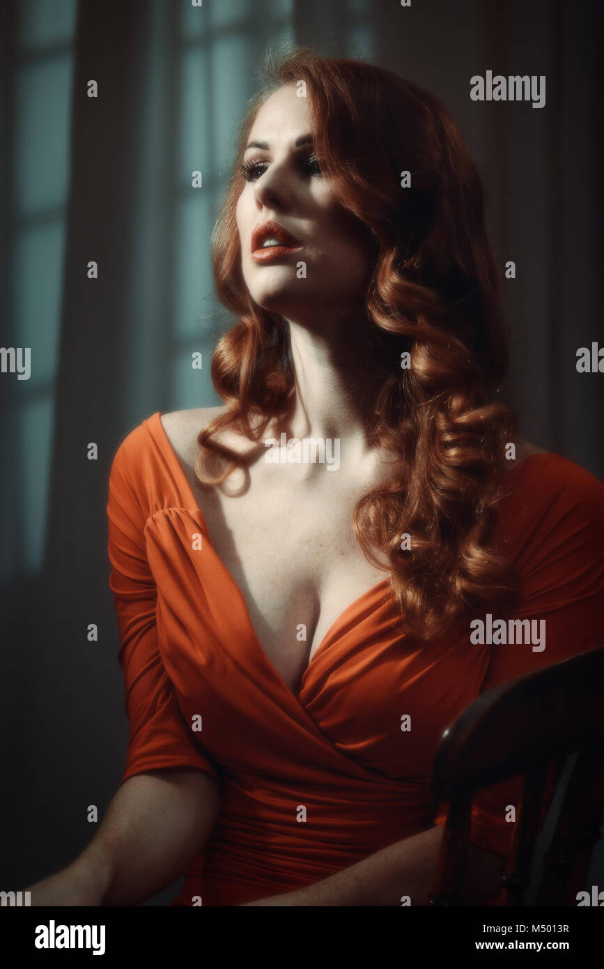 Femme aux longs cheveux rouges - éclairage cinématographique spectaculaire Banque D'Images