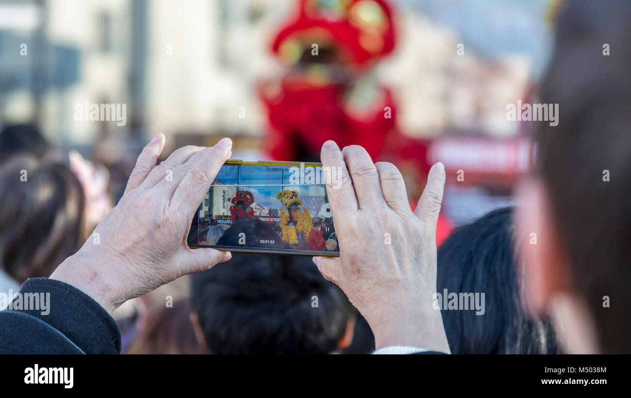 Noisy-le-Grand, France. Feb 18, 2018. Image de la main d'un tournage à l'aide d'une femme senior smartphone pendant la parade du Nouvel An chinois à Nosy-le-Grand sur février 18,2018. Credit : Radu Razvan/Alamy Live News Banque D'Images