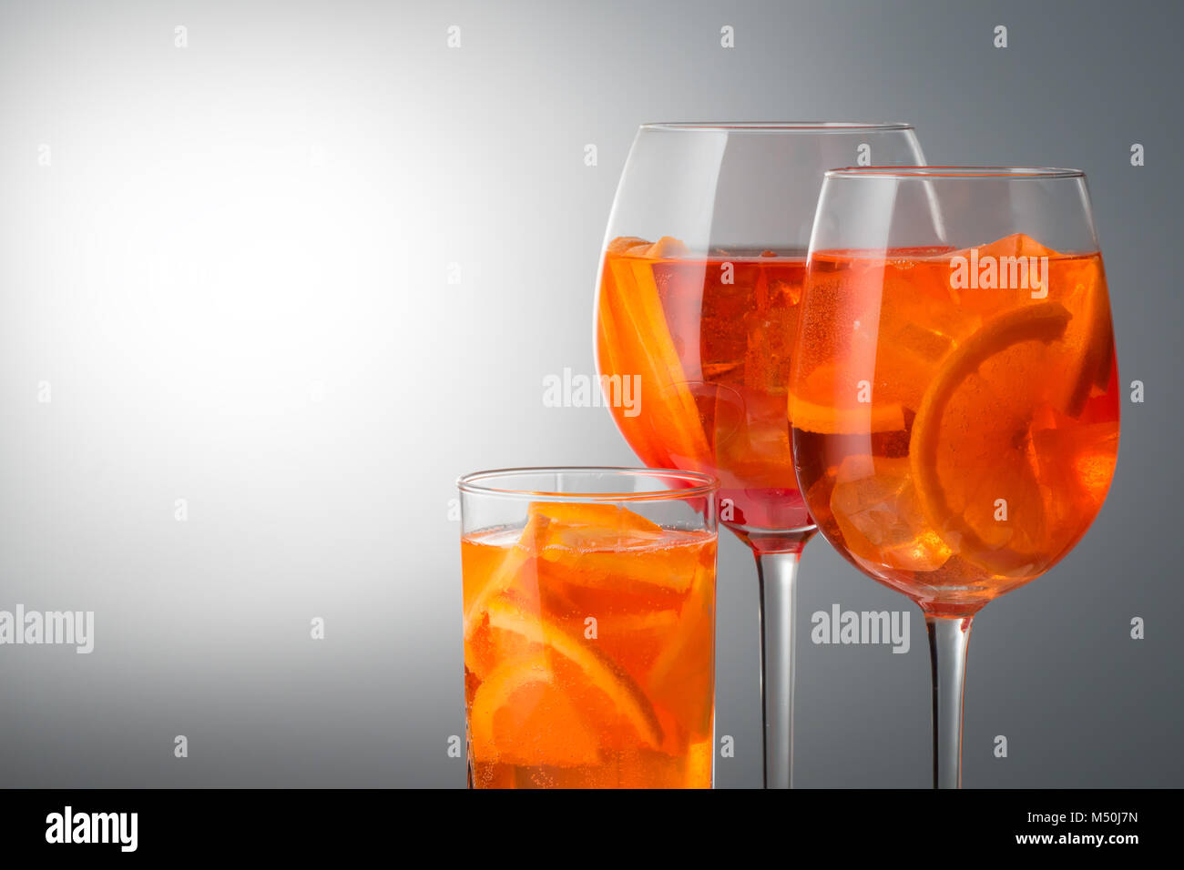 Populaires de l'été à la mode italienne verre rafraîchissant Aperol spritz cocktail sans alcool faiblement dans un verre avec de la glace en verre décoré de tranches d'orange sur whit Banque D'Images