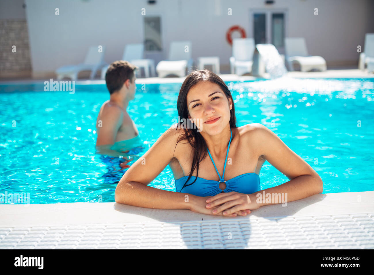 Smiling cheerful woman swimming in pool clairement sur une journée ensoleillée.s'amuser en vacances pool party.Friendly female bénéficiant d'hôtel relaxant locations.Somme Banque D'Images