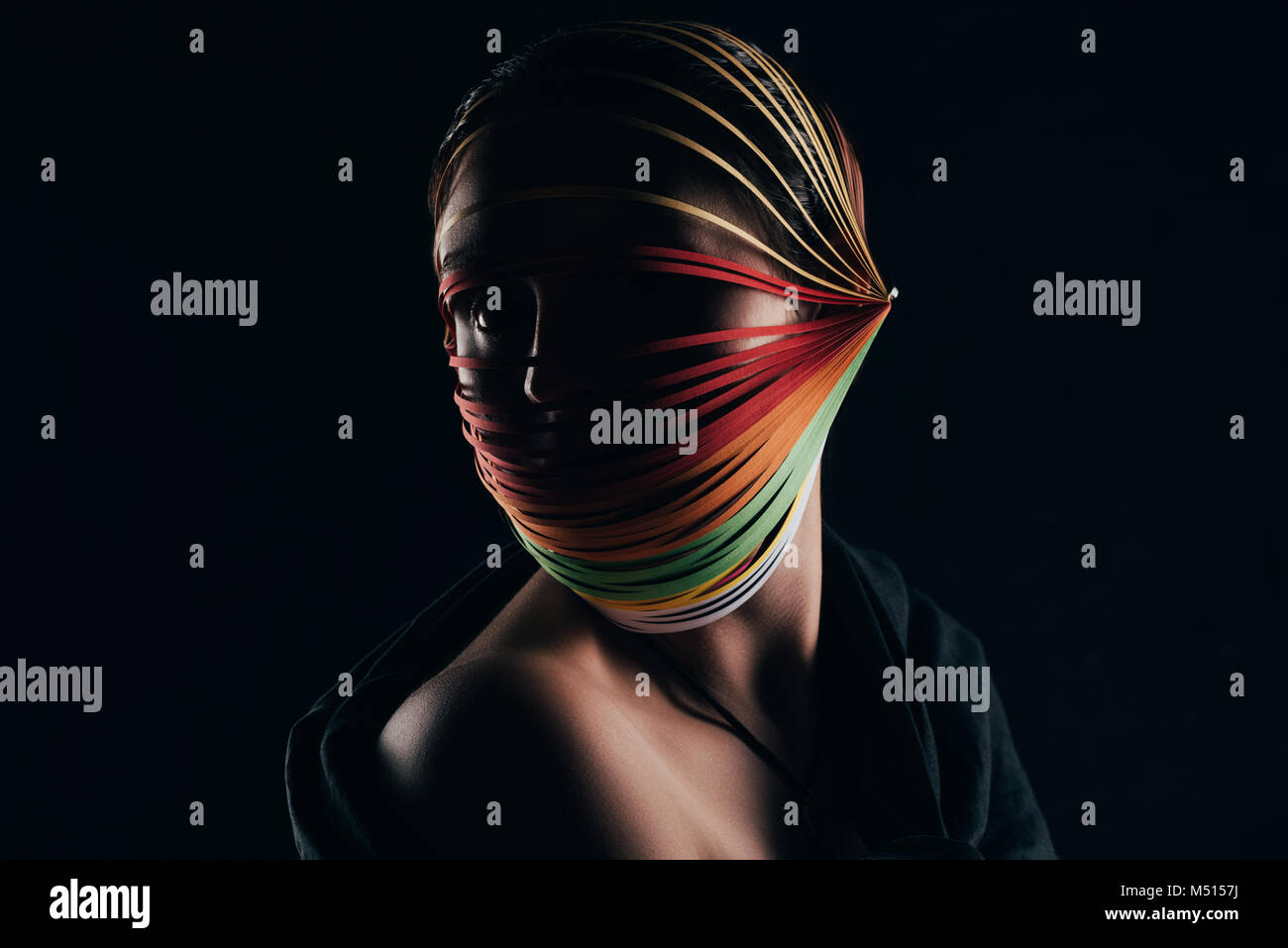 Femme avec du papier de couleur à la tête de canetage loin isolated on black Banque D'Images