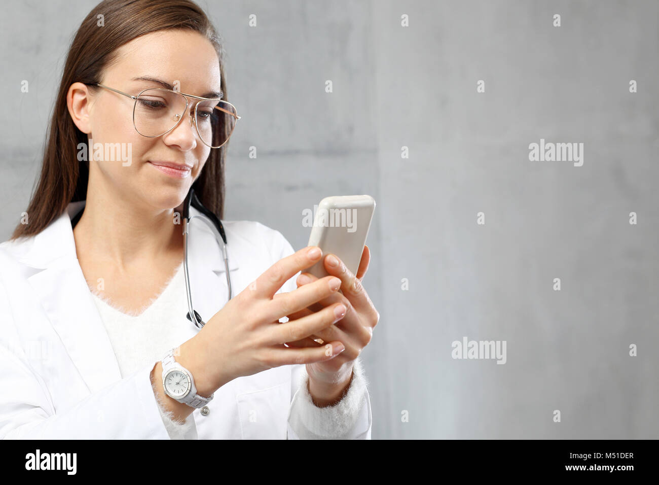 Médecin avec un téléphone. Le médecin envoie un message texte. Banque D'Images