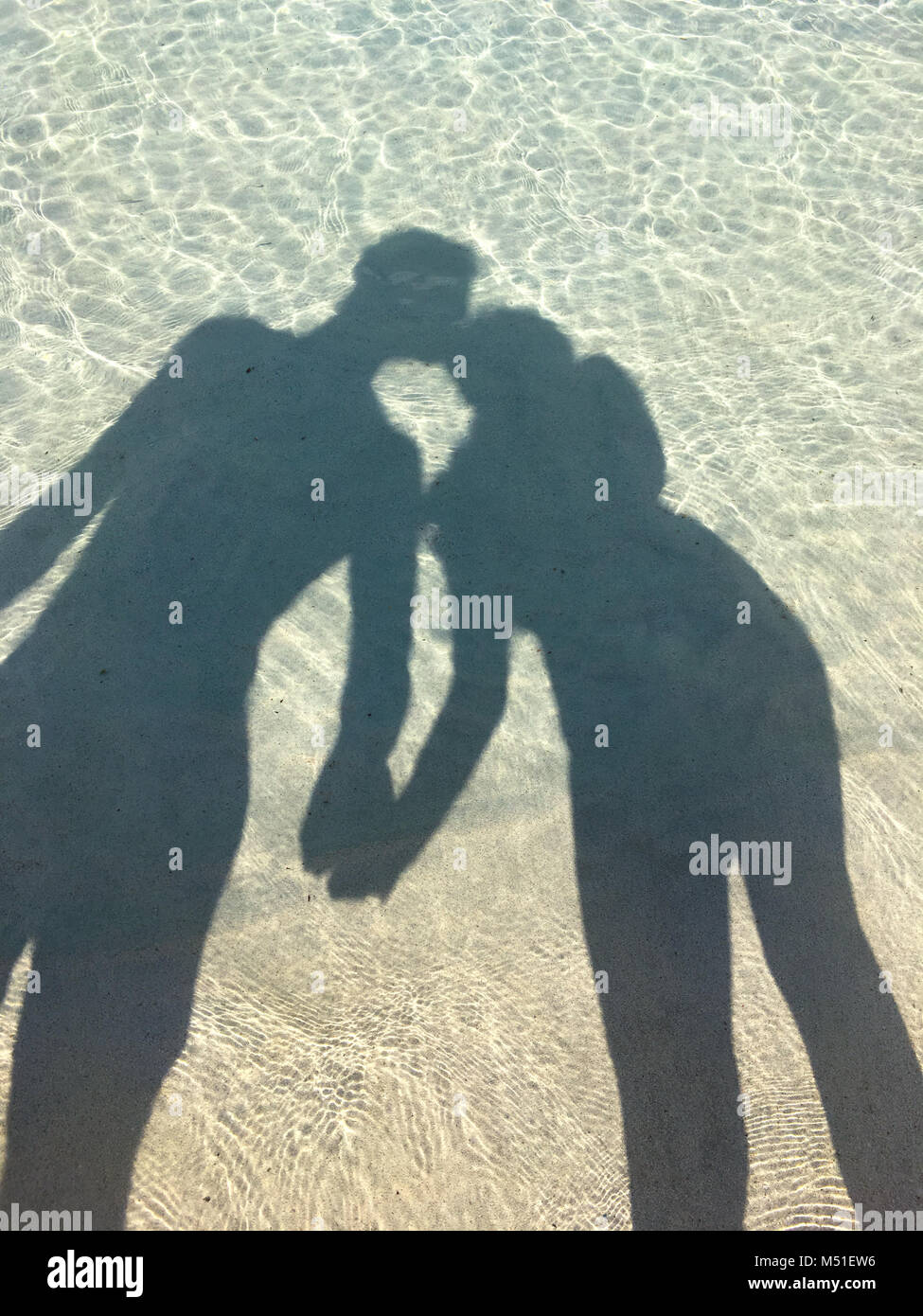 Ombre d'un couple dans l'océan qui s'embrassent et tenir la main Photo  Stock - Alamy