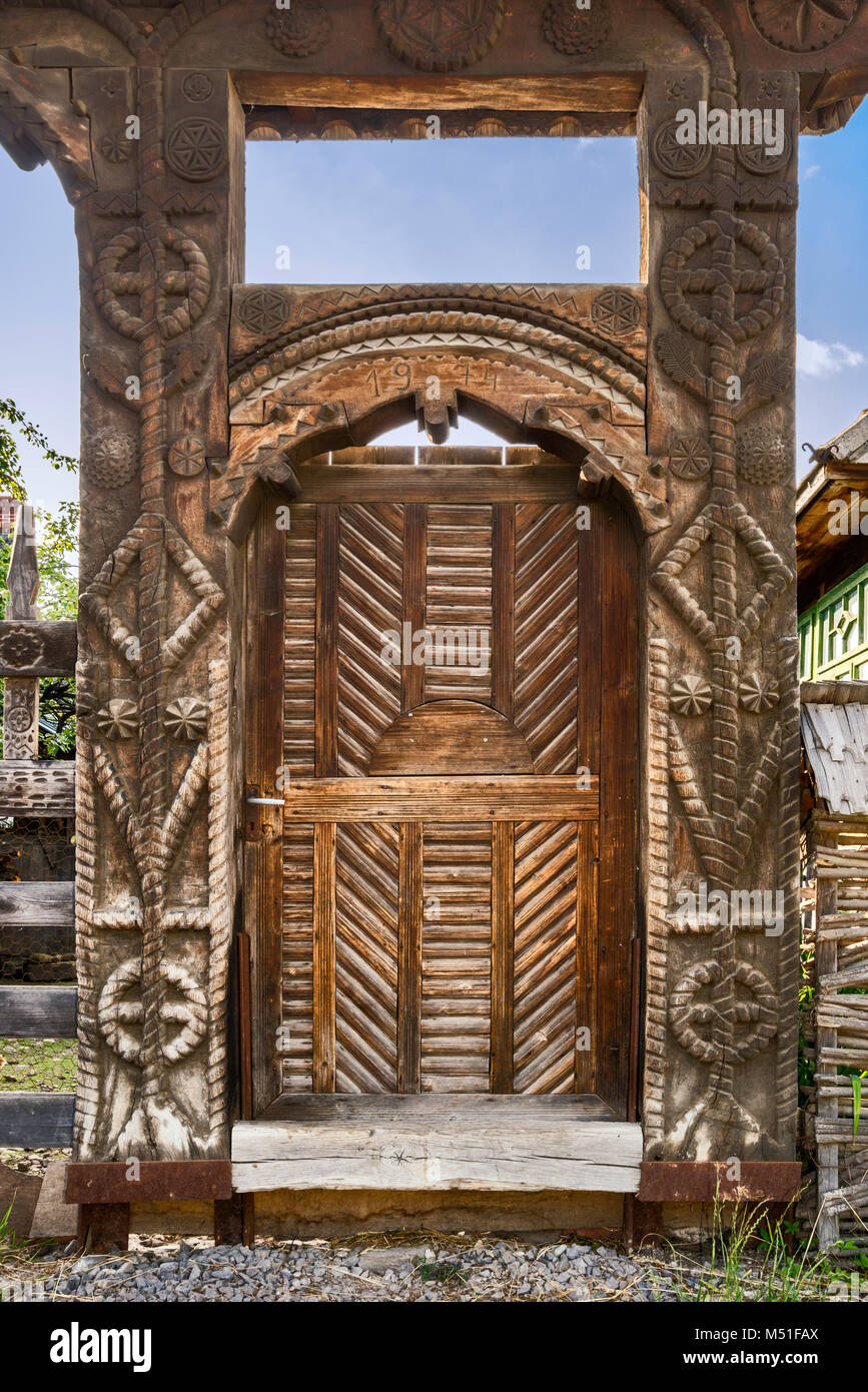 Porte en bois sculpté à ferme en village de Mara, région du Maramures, Roumanie Banque D'Images