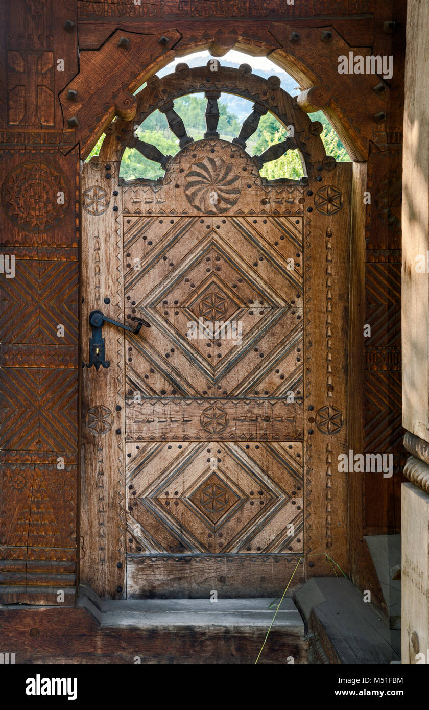 Porte en bois sculpté à ferme en village de Mara, région du Maramures, Roumanie Banque D'Images