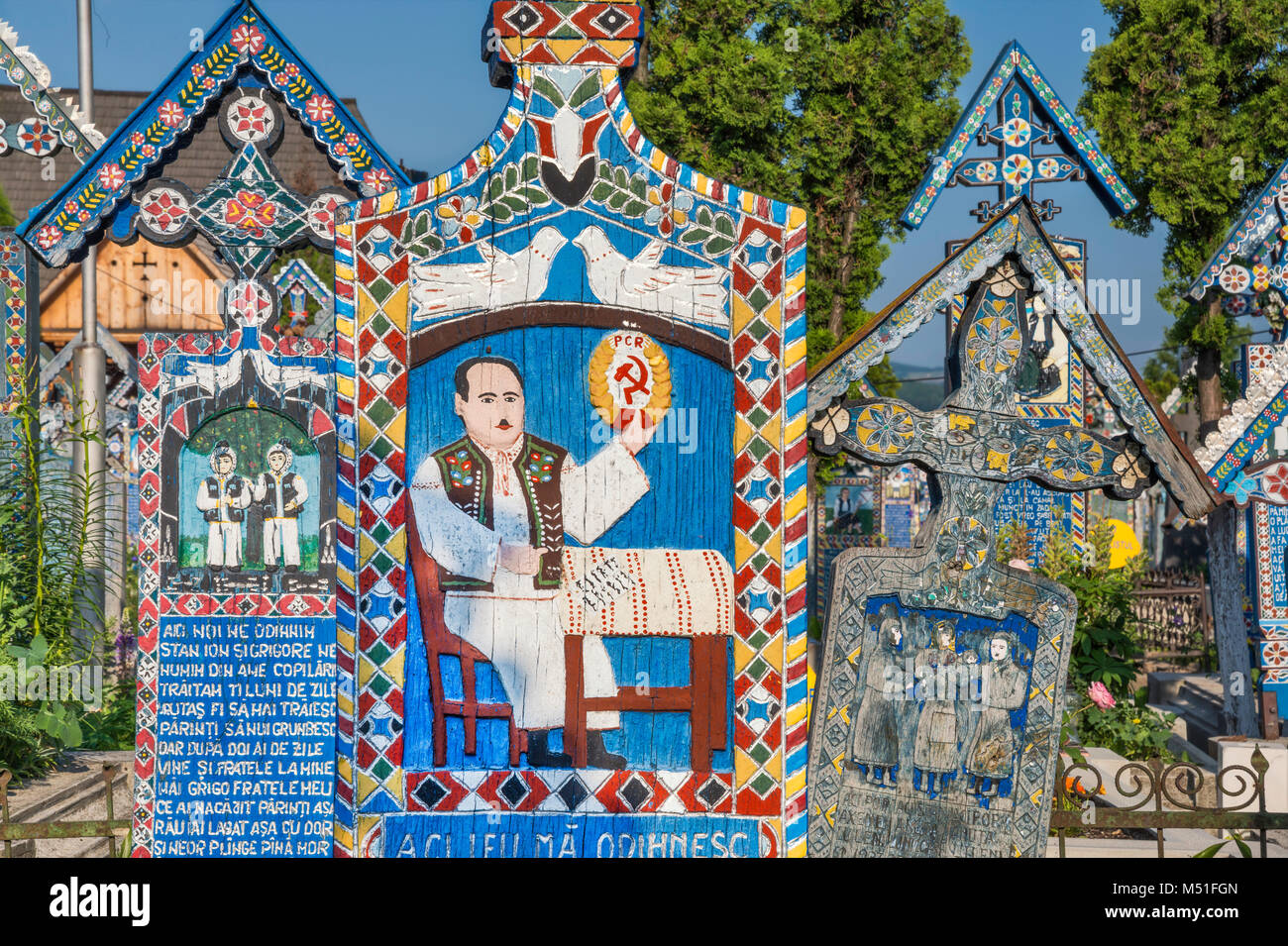 Panneaux en bois sculptés avec d'épitaphes, y compris la drépanocytose et d'un marteau, à graves, Cimetière Joyeux (Cimitirul Vesel) de Sapanta, Maramures, Roumanie Banque D'Images