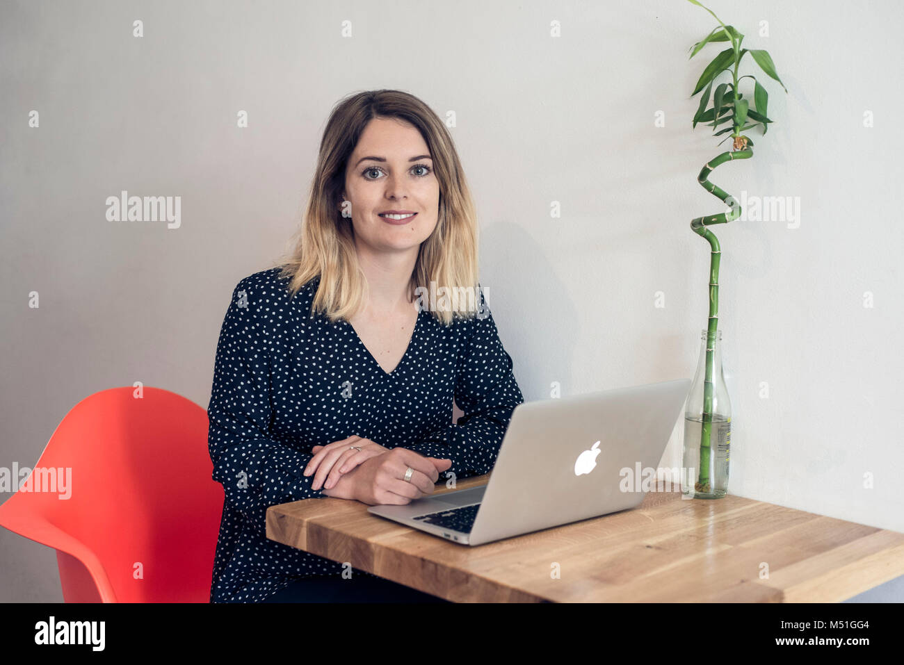 Une jeune femme jeune écrit un blog depuis un café dans un autre et de façon moderne de travailler sur son ordinateur portable tout en buvant un café Banque D'Images