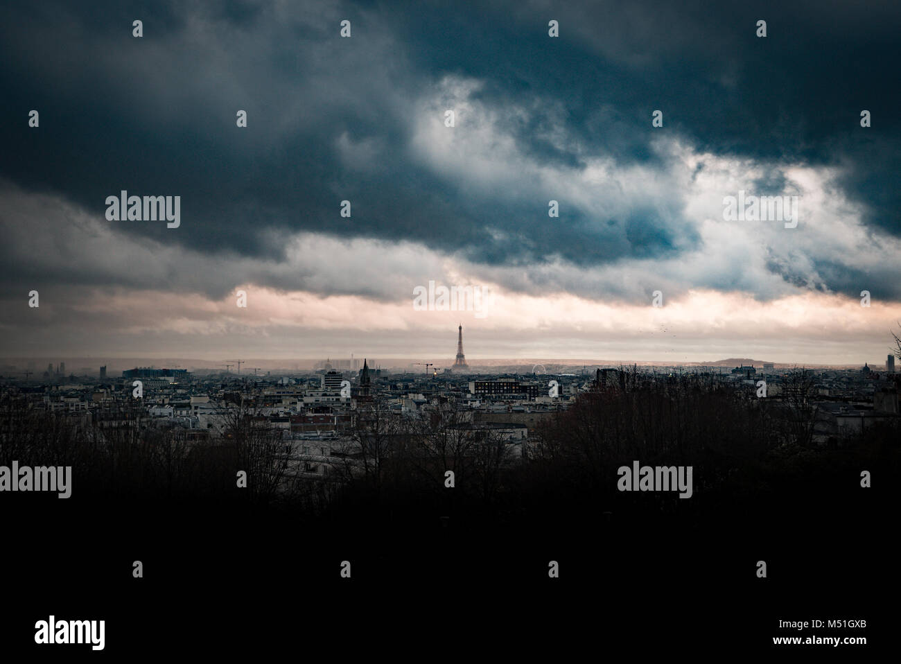 Dans les nuages orageux sombre très dramatique et menaçant Ciel de coucher du soleil sur Paris et la tour Eiffel, de loin Banque D'Images