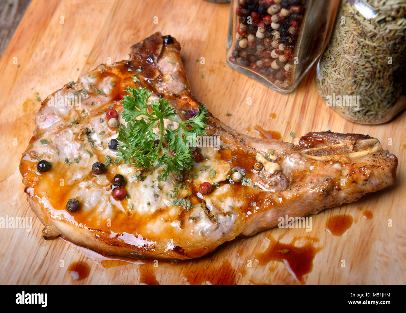 Côtelettes de porc au grill steak au poivre sur feu de charbon ajouter sur la sauce barbecue avec l'éclairage extérieur et éclairage flash. Banque D'Images