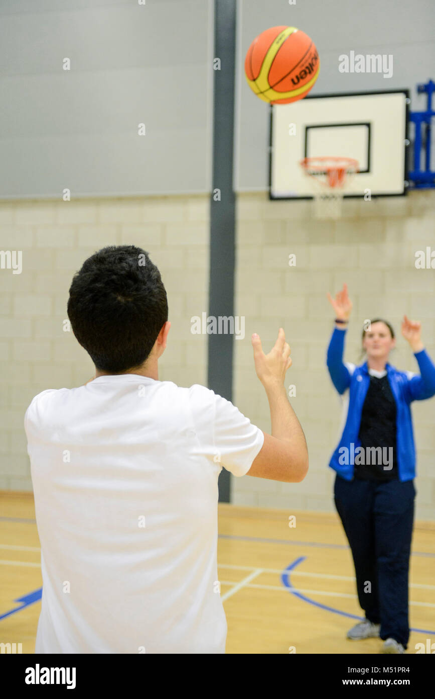 Les élèves de l'école jeu sport dans la piscine salle de sport dans leur école / collège Banque D'Images