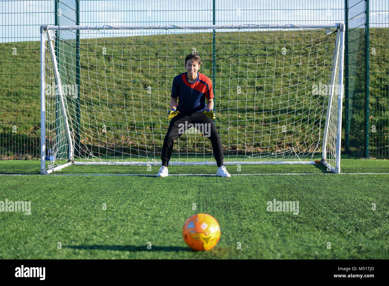 Les élèves de l'école ayant une leçon de football à améliorer leurs compétences en jouant des sports sur le picth de football Banque D'Images