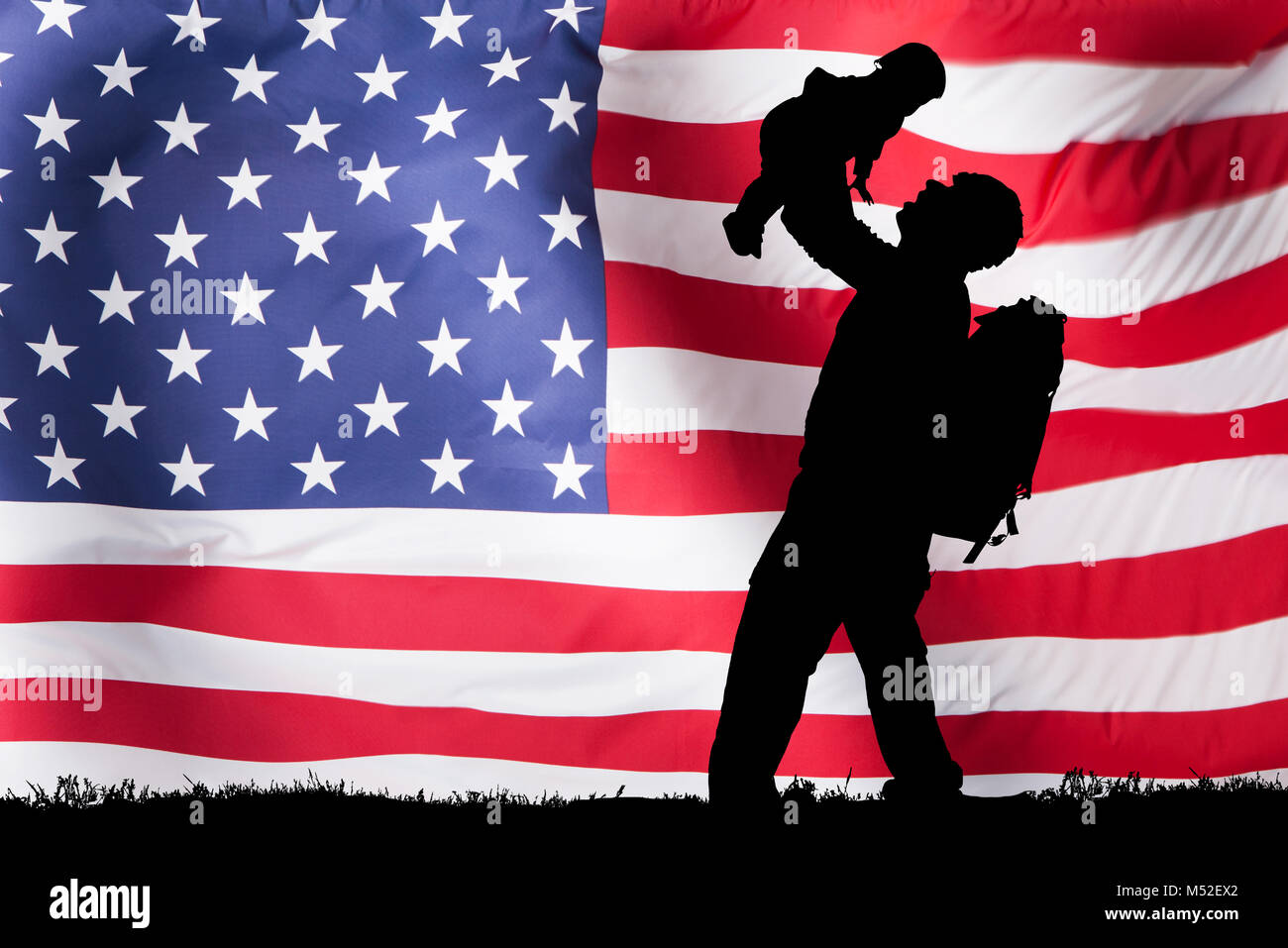 Silhouette d'un soldat portant son enfant in front of American Flag Banque D'Images