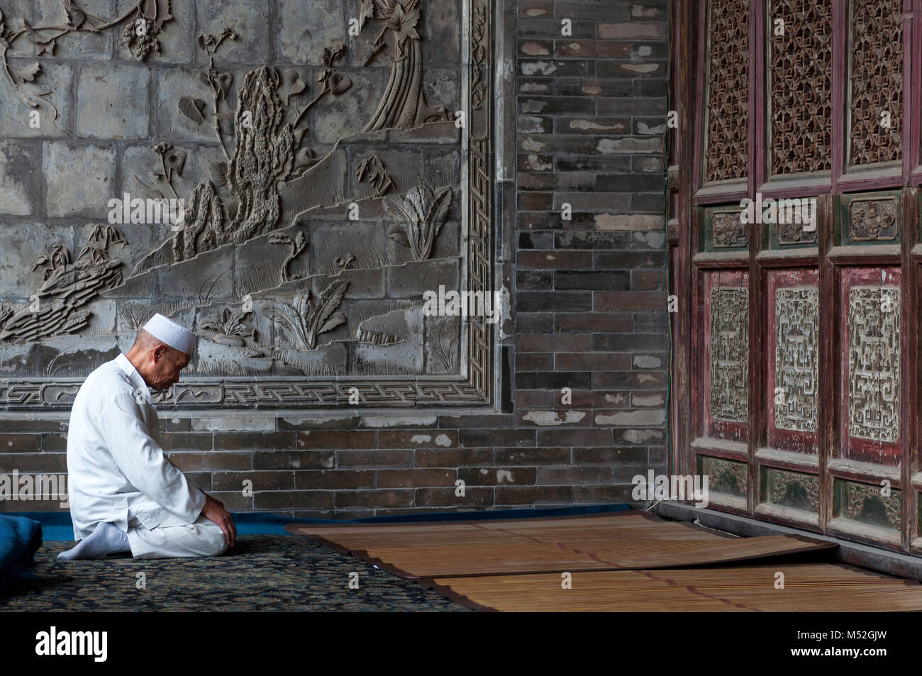 Xi'an, Chine - 5 août 2012 : Un homme priant au Xi'an grande mosquée de la ville de Xi'An en Chine, l'Asie. Banque D'Images