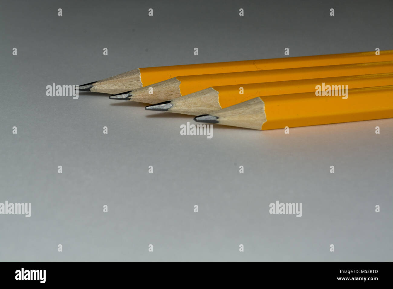 Quatre crayons jaune dans une rangée, isolated on white Banque D'Images