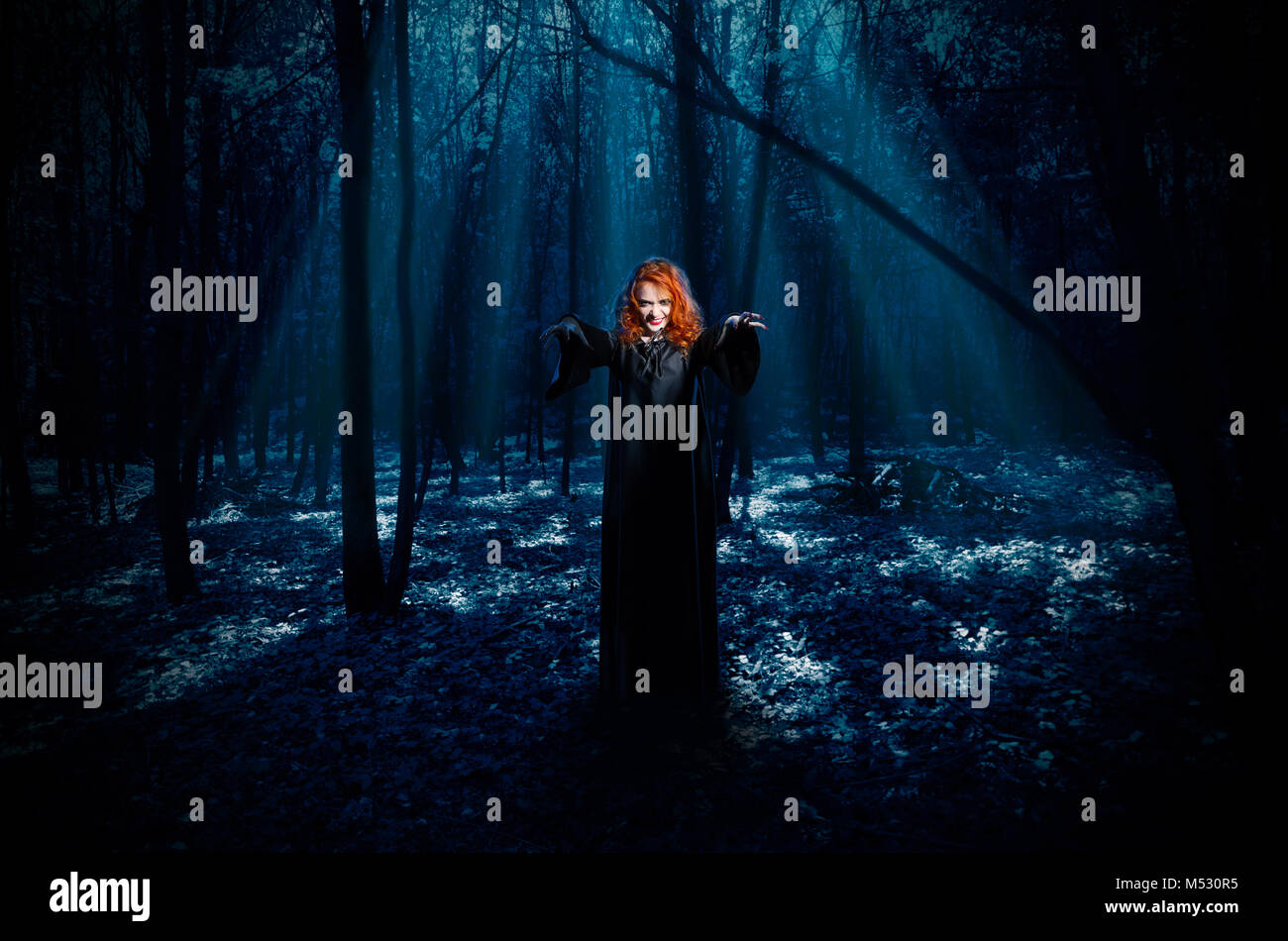 Jeune sorcière dans la forêt la nuit Banque D'Images