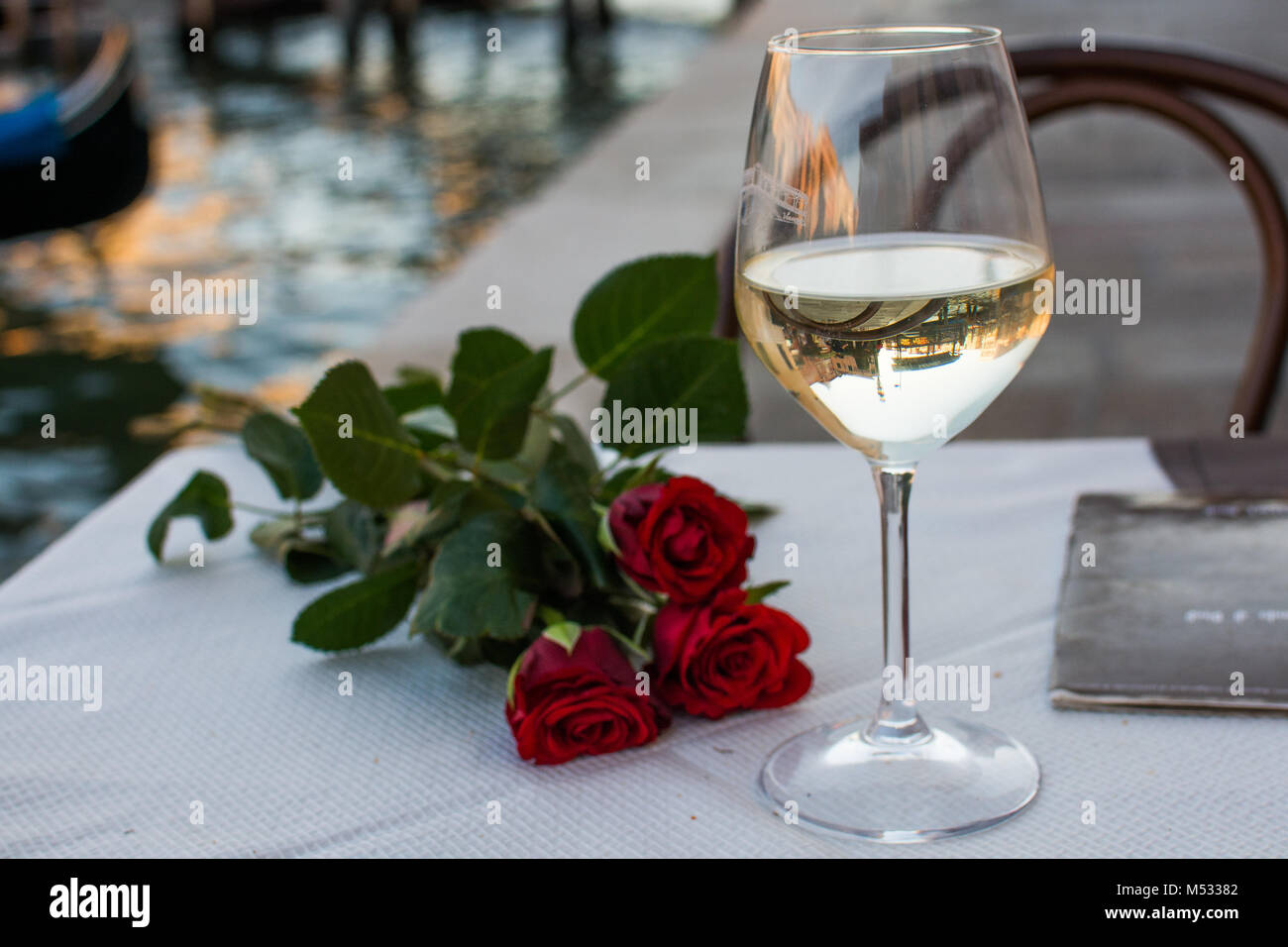 Boire du vin blanc à une date avec des roses rouges et un repas sur la grande, Venise, Italie Banque D'Images