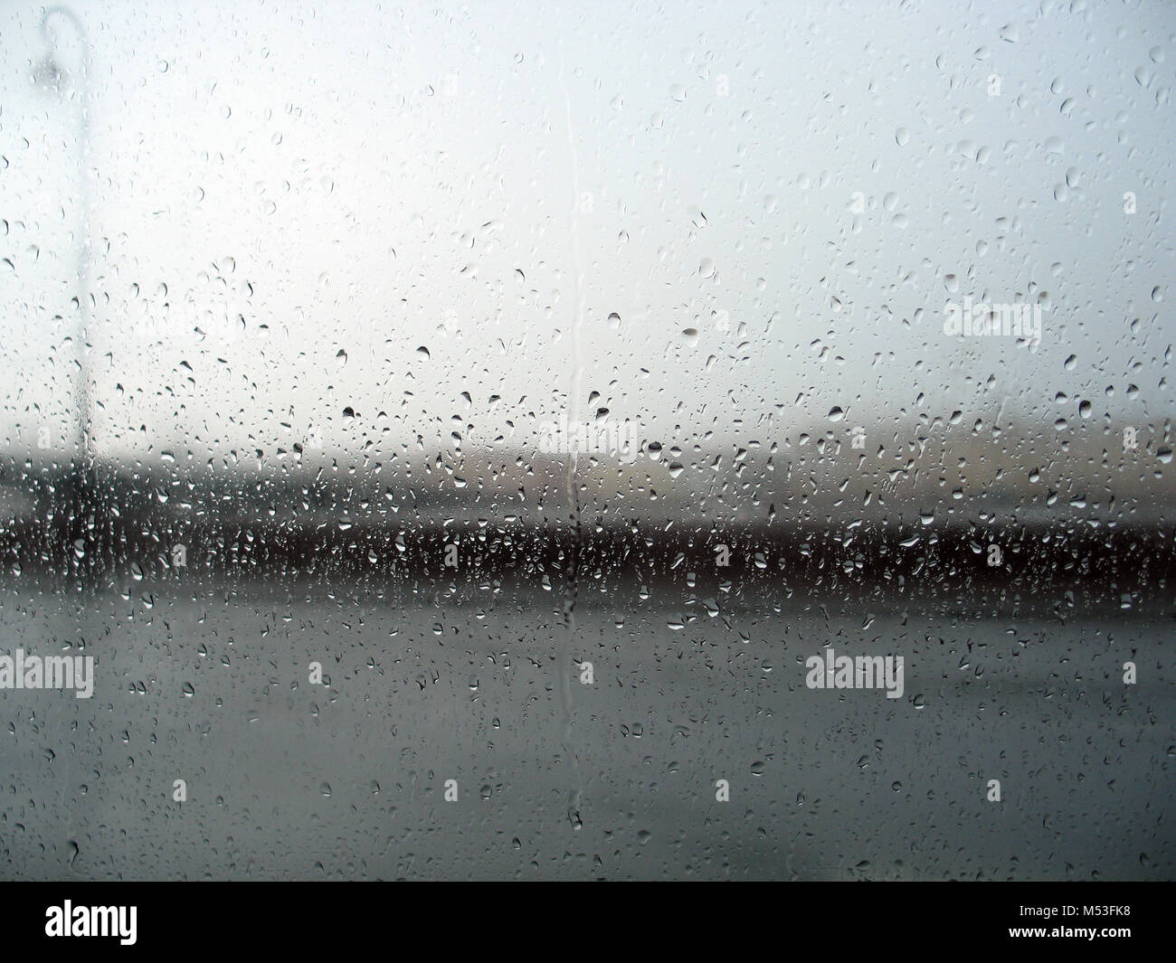 Le paysage derrière la vitre avec gouttes de pluie au cours de l'orage Banque D'Images