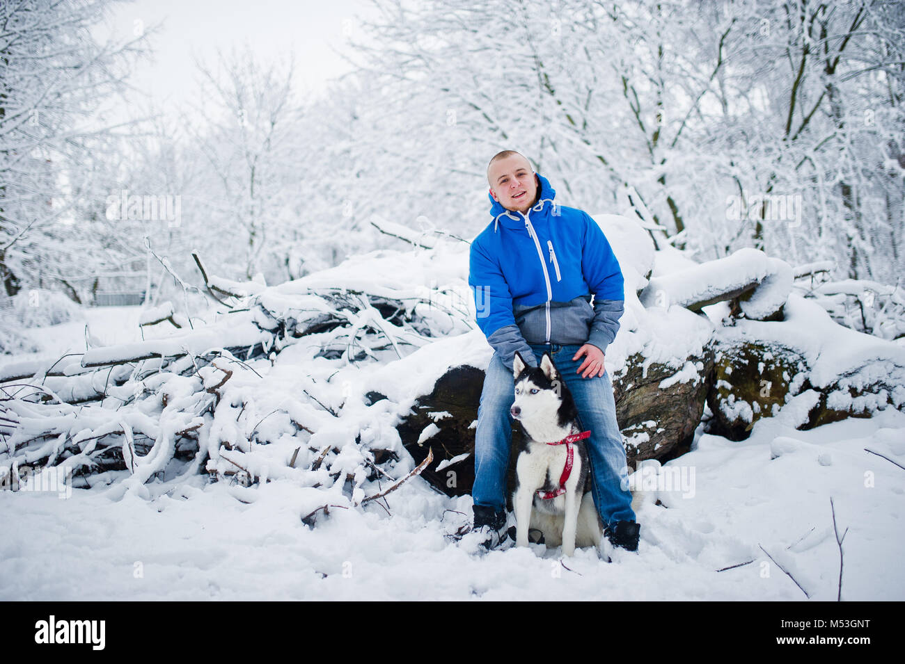 Homme avec chien husky au parc enneigé en hiver. Banque D'Images Homme avec chien husky au parc enneigé en hiver. Banque D'Images