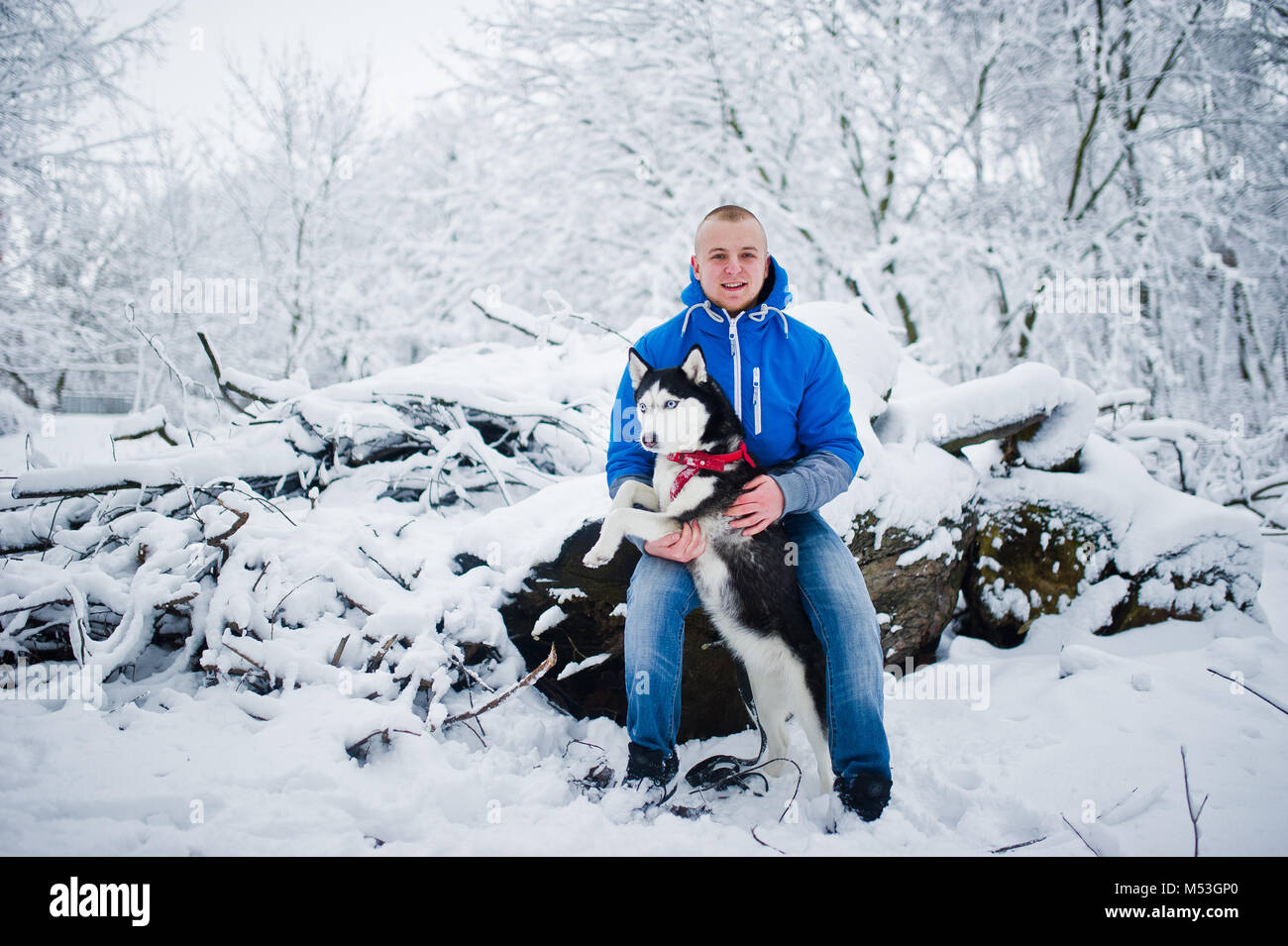 Homme avec chien husky au parc enneigé en hiver. Banque D'Images Homme avec chien husky au parc enneigé en hiver. Banque D'Images