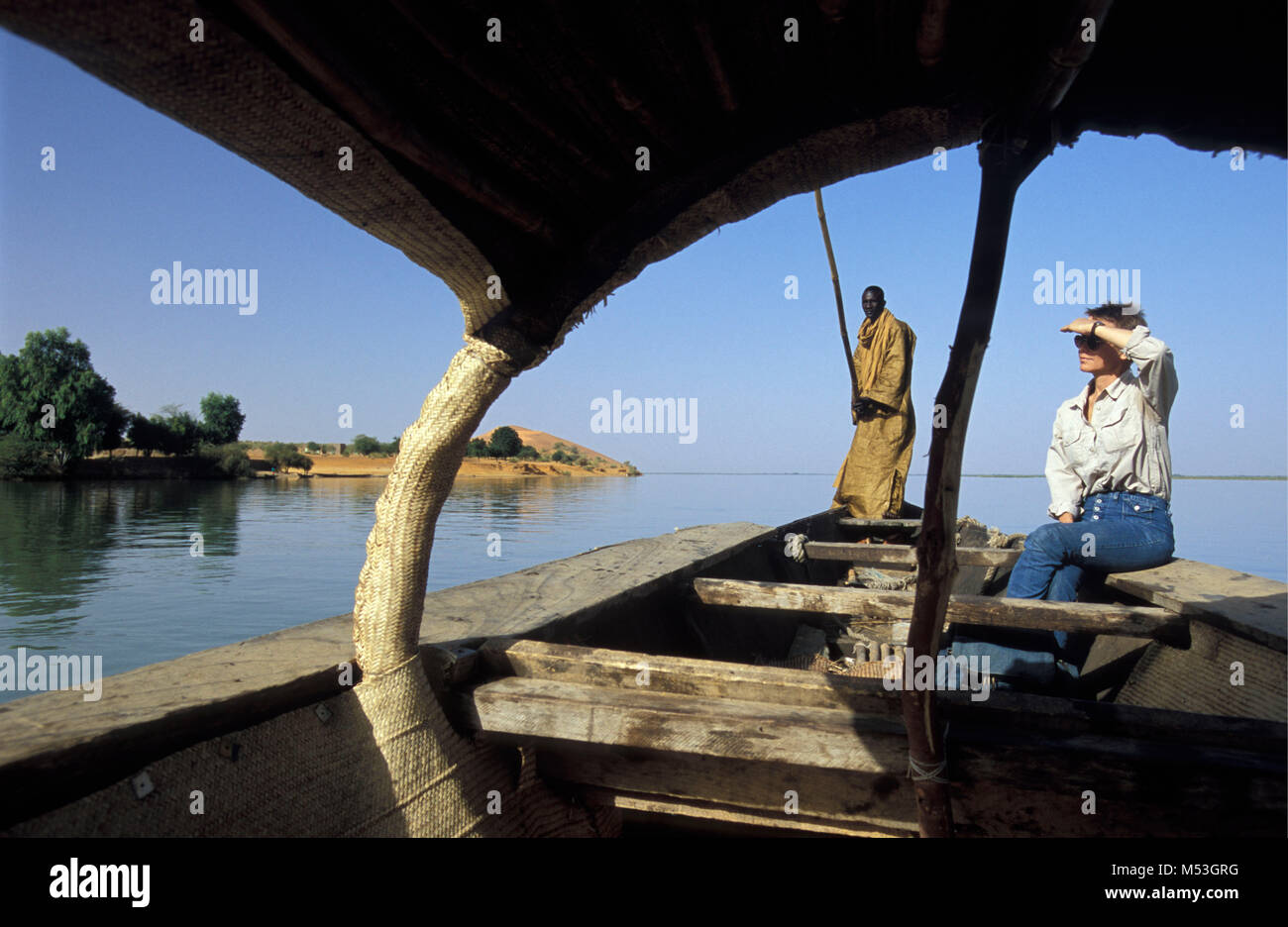 Le Mali. Gao. Sahel. L'homme et sur le bateau touristique sur fleuve Niger. Contexte : la plus grande dune de sable Le Mali a appelé DUNE ROSE. Banque D'Images