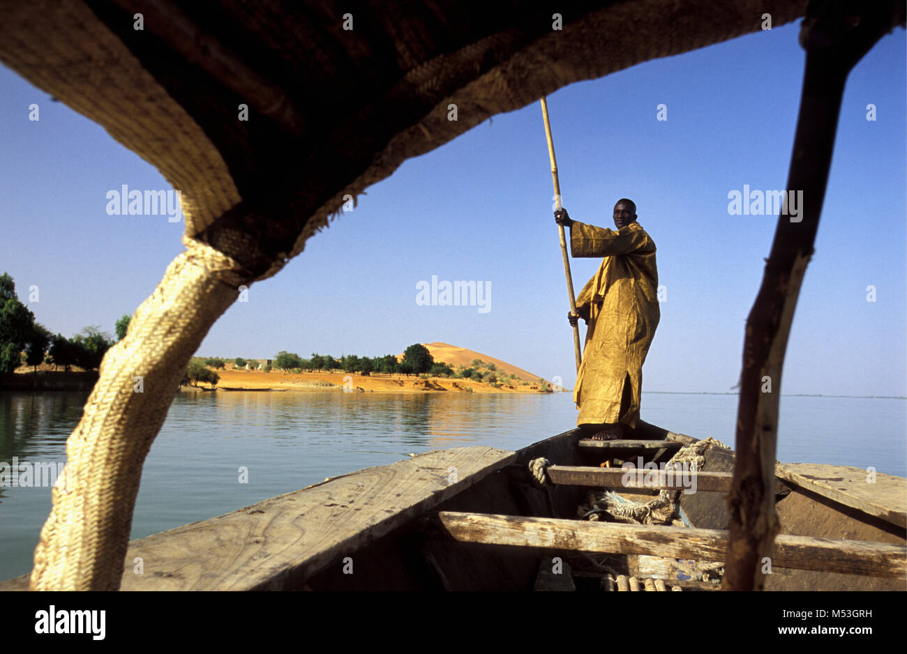 Le Mali. Gao. Sahel. L'homme sur le bateau sur le fleuve Niger. Contexte : la plus grande dune de sable Le Mali a appelé DUNE ROSE. Banque D'Images
