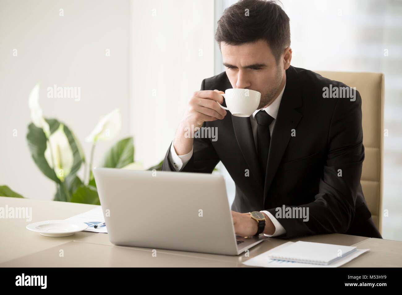 Businessman drinking coffee quand working in office Banque D'Images