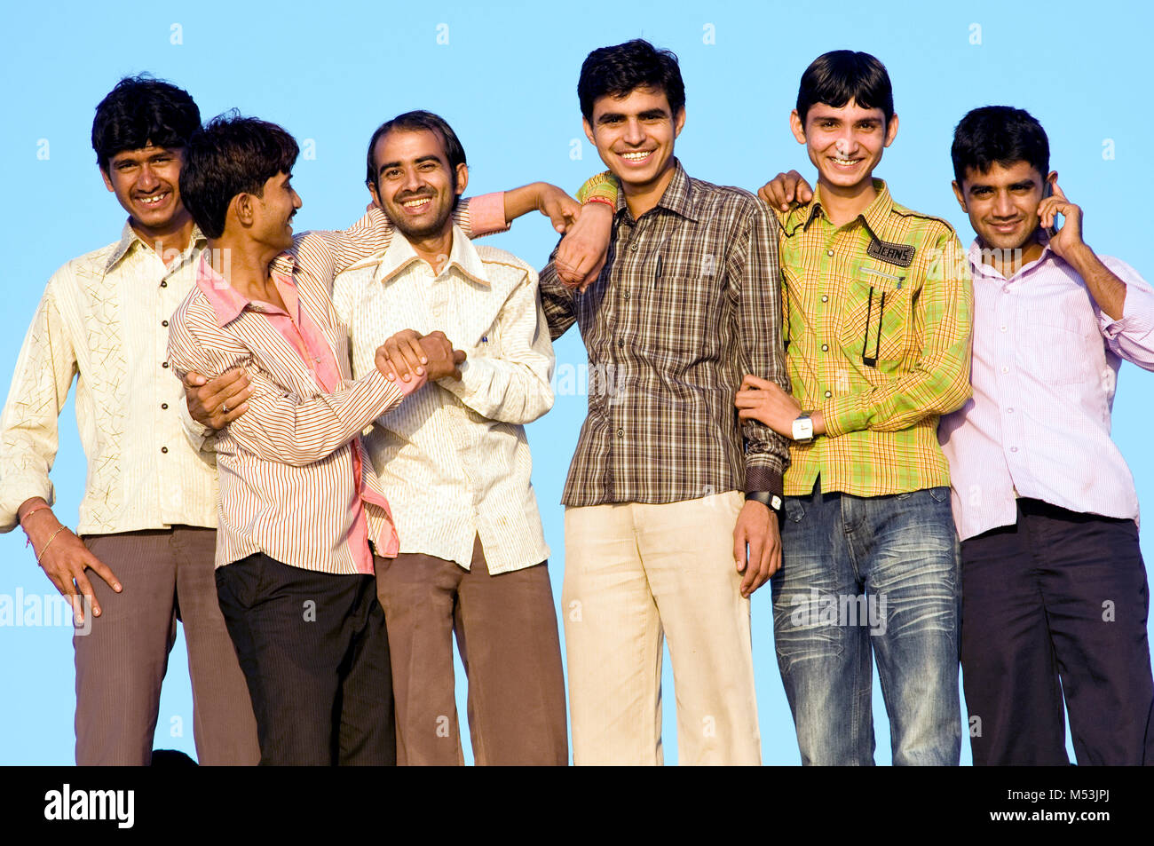 Un groupe de six jeunes hommes sur le rivage de la plage de Chowpatty, Mumbai, Inde Banque D'Images