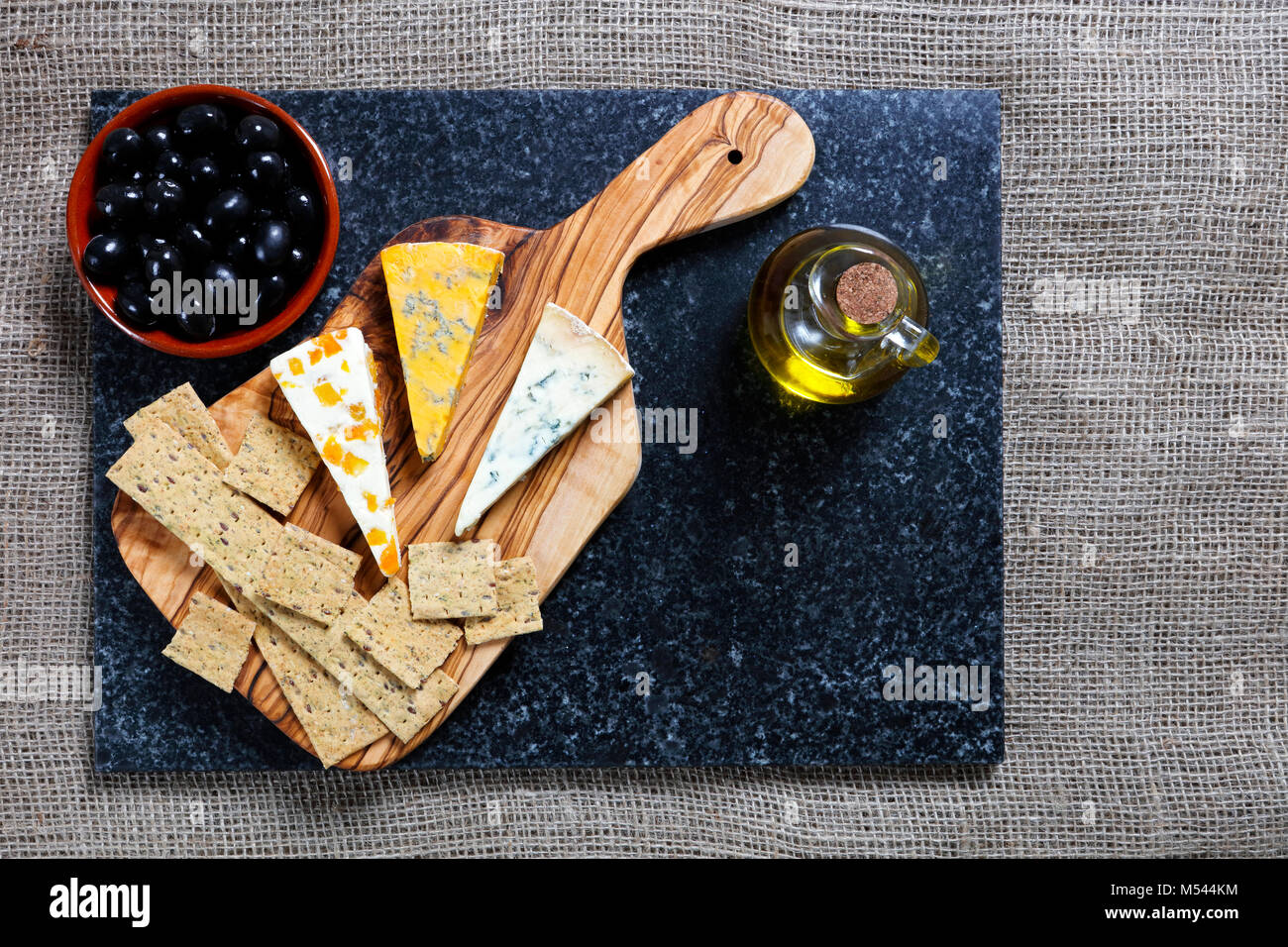 Alimentation - bleu foncé et bleu fromages Stiltons Shropshire sur une carte en bois d'olivier Banque D'Images
