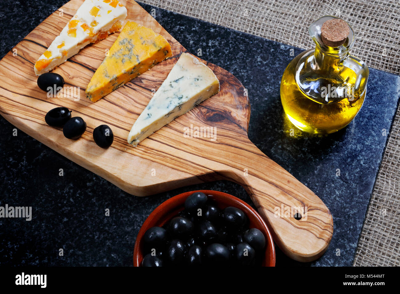 Alimentation - bleu foncé et bleu fromages Stiltons Shropshire sur une carte en bois d'olivier Banque D'Images