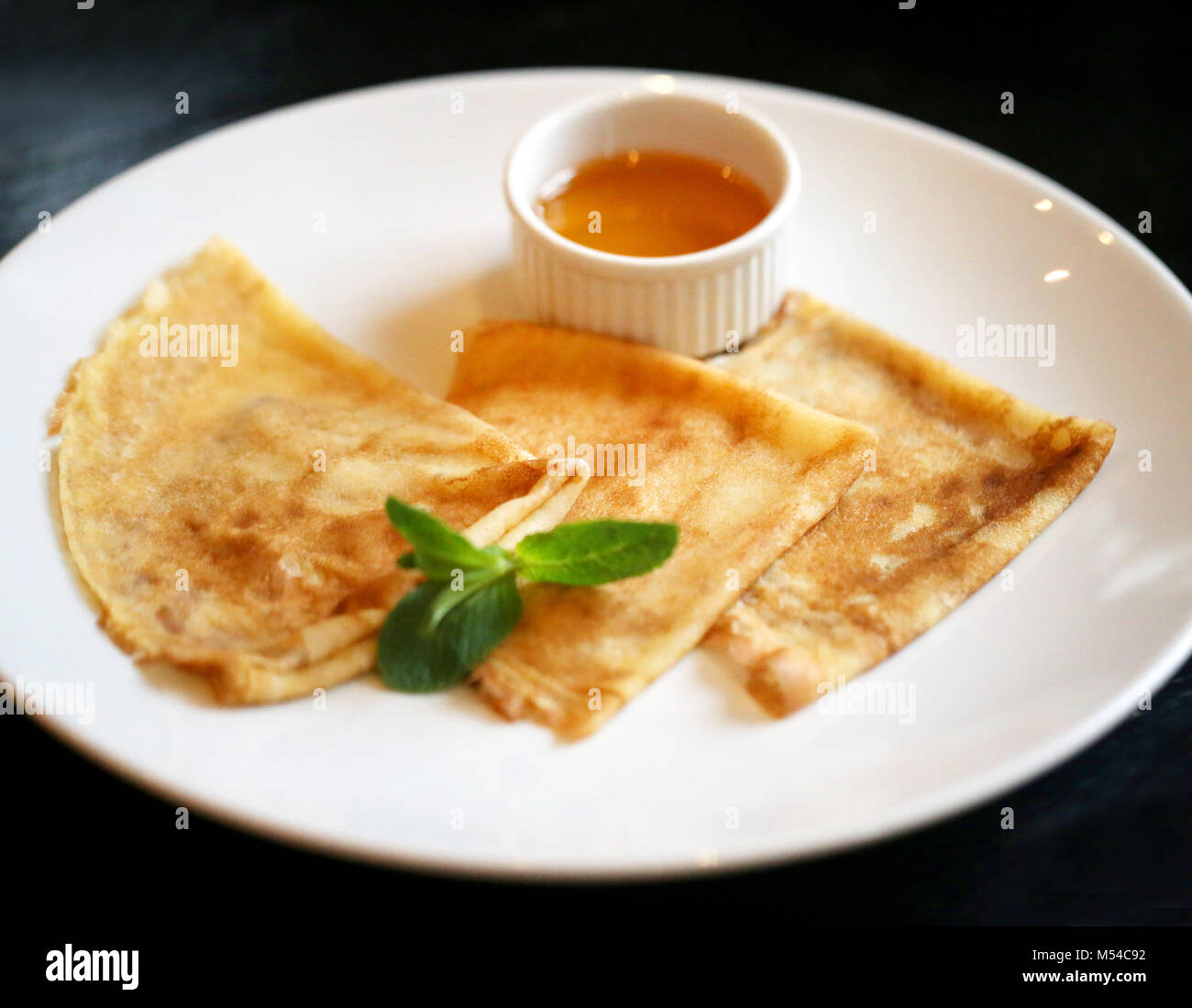 Photo de savoureuses crêpes lumineux macro avec miel Banque D'Images