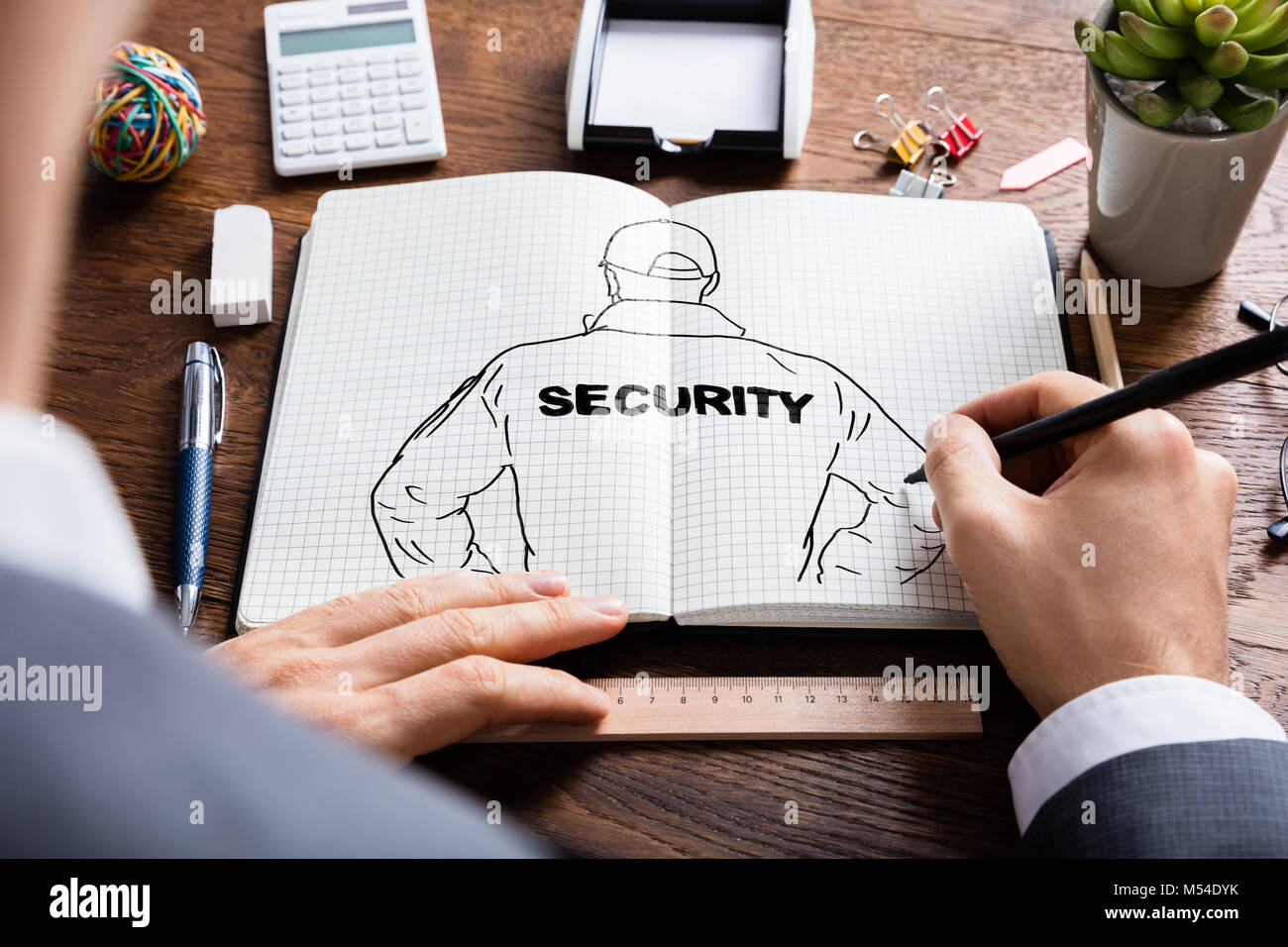 Close-up of Businessman croquis dessin de gardien de sécurité dans un livre Banque D'Images